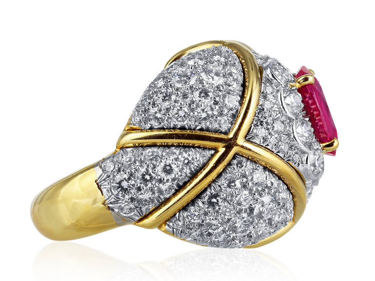 18 karat yellow gold and platinum ring consisting of 1 oval ruby measuring approximately 9.34 x 7.08 millimeters with a AGL cert #CS 61917 stating Burma No Heat, surrounded by round diamonds with a criss cross pattern in yellow gold, signed David
