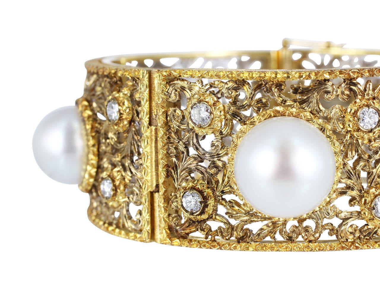Two tone 18 karat white and yellow gold open work bracelet set with five 11.50-11.75mm South Sea pearls and full cut diamond accents, signed M. Buccellati.