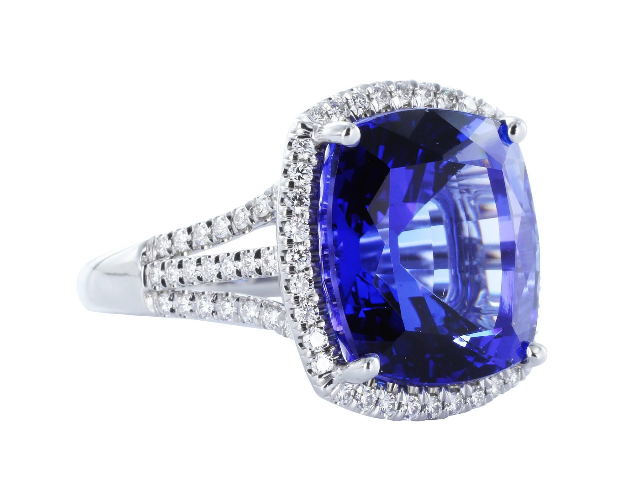 18 karat white gold custom made cluster ring consisting of 1 cushion cut Tanzanite weighing 16.17 carats. The center stone is accented by a halo of full cut diamonds, a tri split shank set with full cut diamonds and 2 bezel set full cut diamonds one