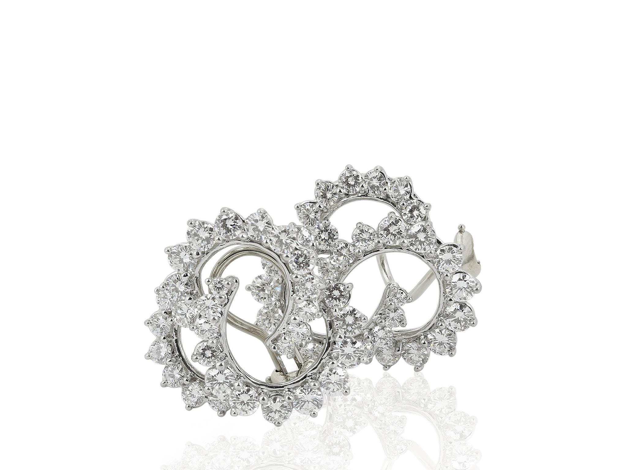 Platinum estate clip earrings consisting of 60 round brilliant cut diamonds having a total weight of approximately 7.50 carats, the earrings are signed Angela Cummings 1995
