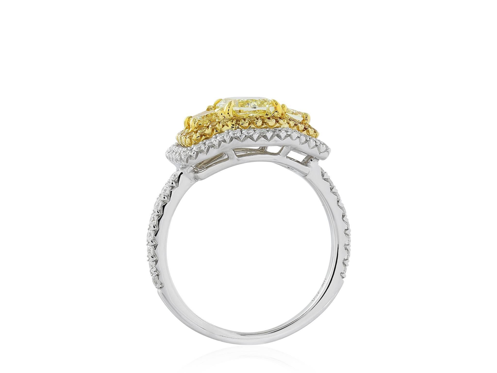 Two tone 18 karat yellow and white gold 3 stone ring consisting of 1 cushion cut canary diamond weighing 1.04 carts, the center stone is flanked by 2 trapezoid canary diamonds weighing .46 carats, the 3 stone are set with .21 carats total weight of