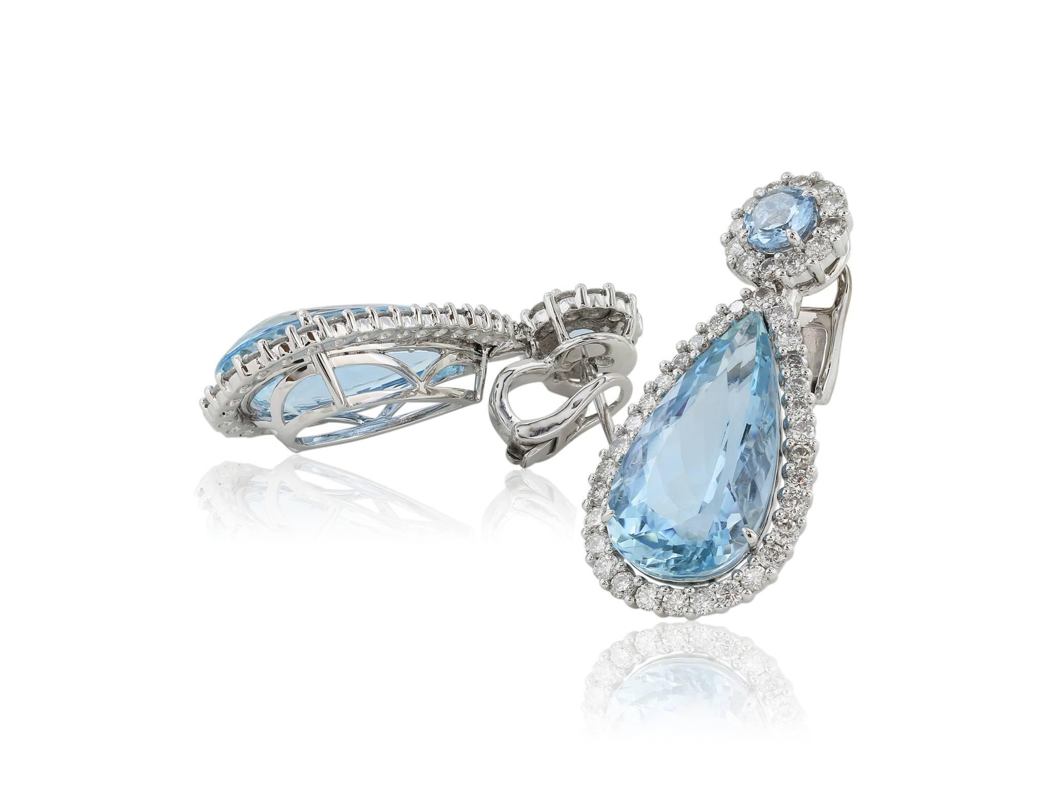 Platinum Pear shape Aquamarine and diamond drop earrings. Consisting of 2 Pear Shape Aquamarines measuring 12.50x33.00 MM and weighing approximately 22 carats surrounded by full cut rbc diamonds having a total weight of approximately 1.75 carats