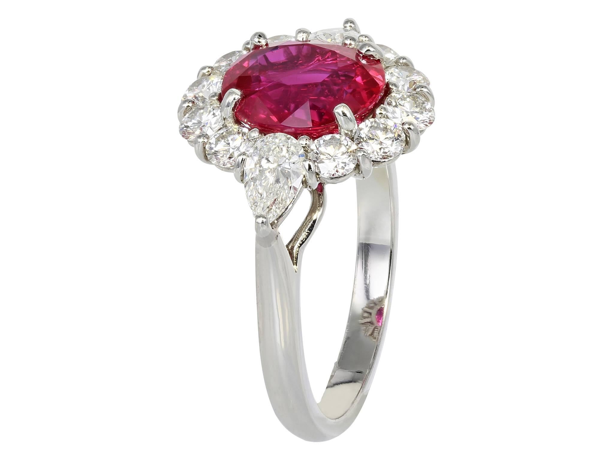 Platinum custom cluster ring consisting of one cushion cut Ruby weighing 3.16 carats, measuring 9.28 x 7.76 x 4.76mm, surrounded by 2 pear shape and 10 round brilliant diamonds with a total weight of 1.28 carats. This Ruby is GIA certified, cert