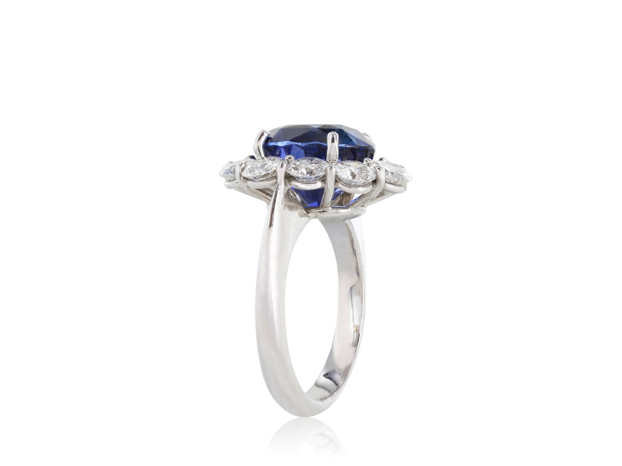 Custom made platinum setting and 18kt white gold shank, GIA Certified sapphire and diamond cluster ring. Consisting of one oval sapphire weighing 7.05 carats surrounded by ten round brilliant cut diamonds having a total weight of 2.52 carats. Ring