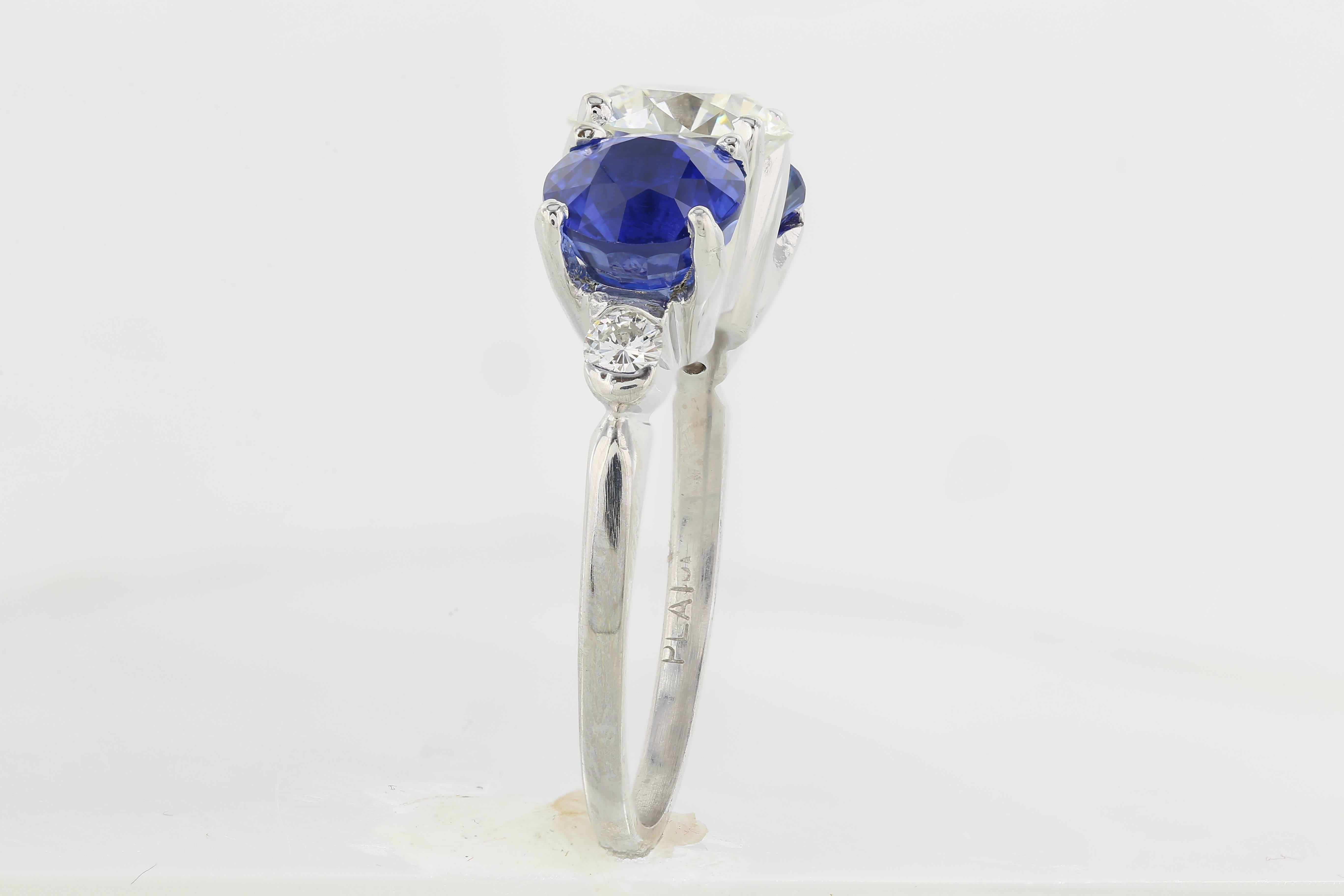 Platinum three stone ring containing one old European cut diamond weighing 1.51 carats with a color and clarity of H/VS1.  The diamond is flanked by two round cut sapphires having a total weight of 3.06 carats.