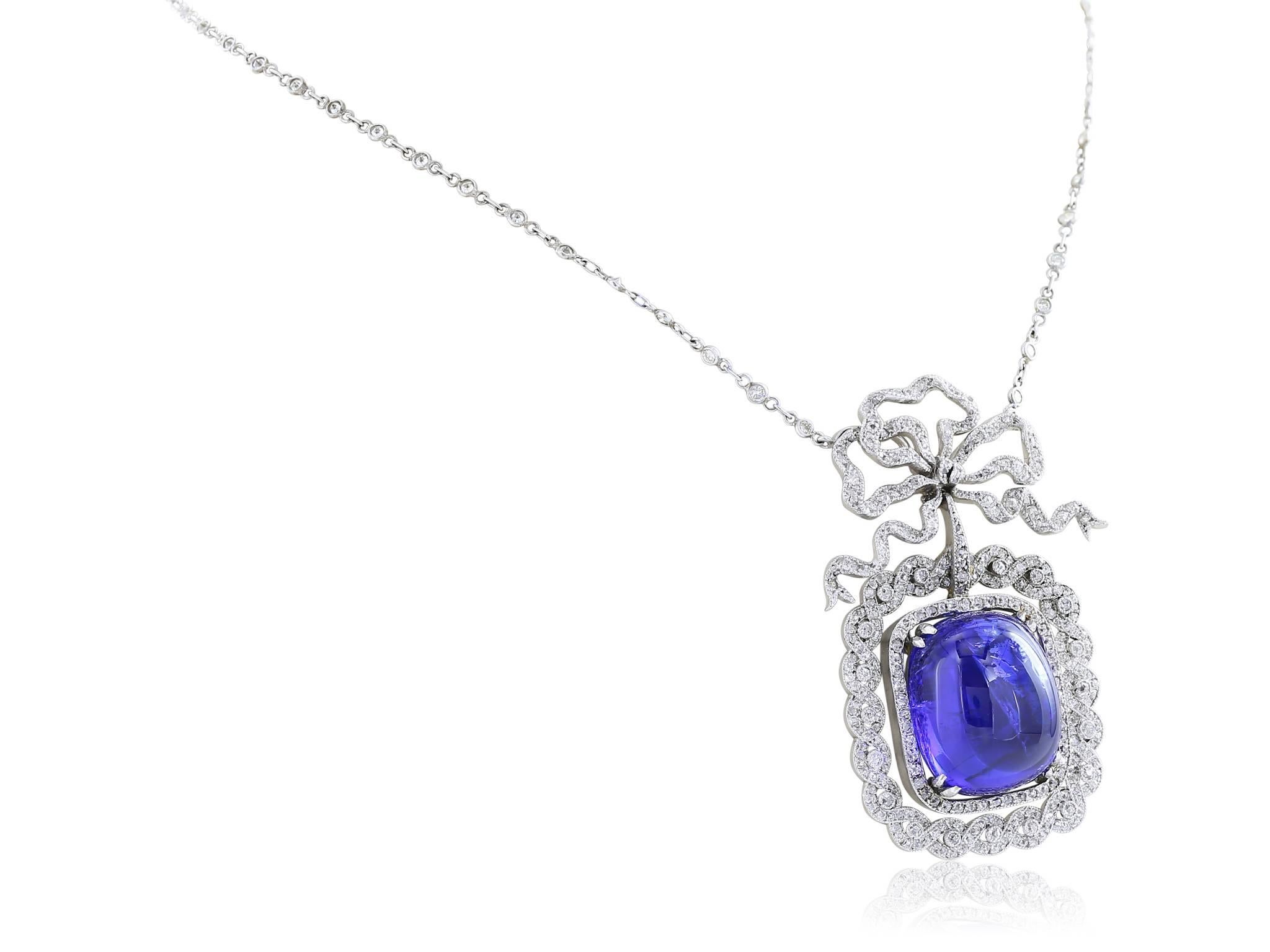 Platinum set Edwardian bow necklace with a 23.91 carat cabochon tanzanite surrounded by a wreath of rose cut diamonds hanging on a diamond-by-the-yard chain.