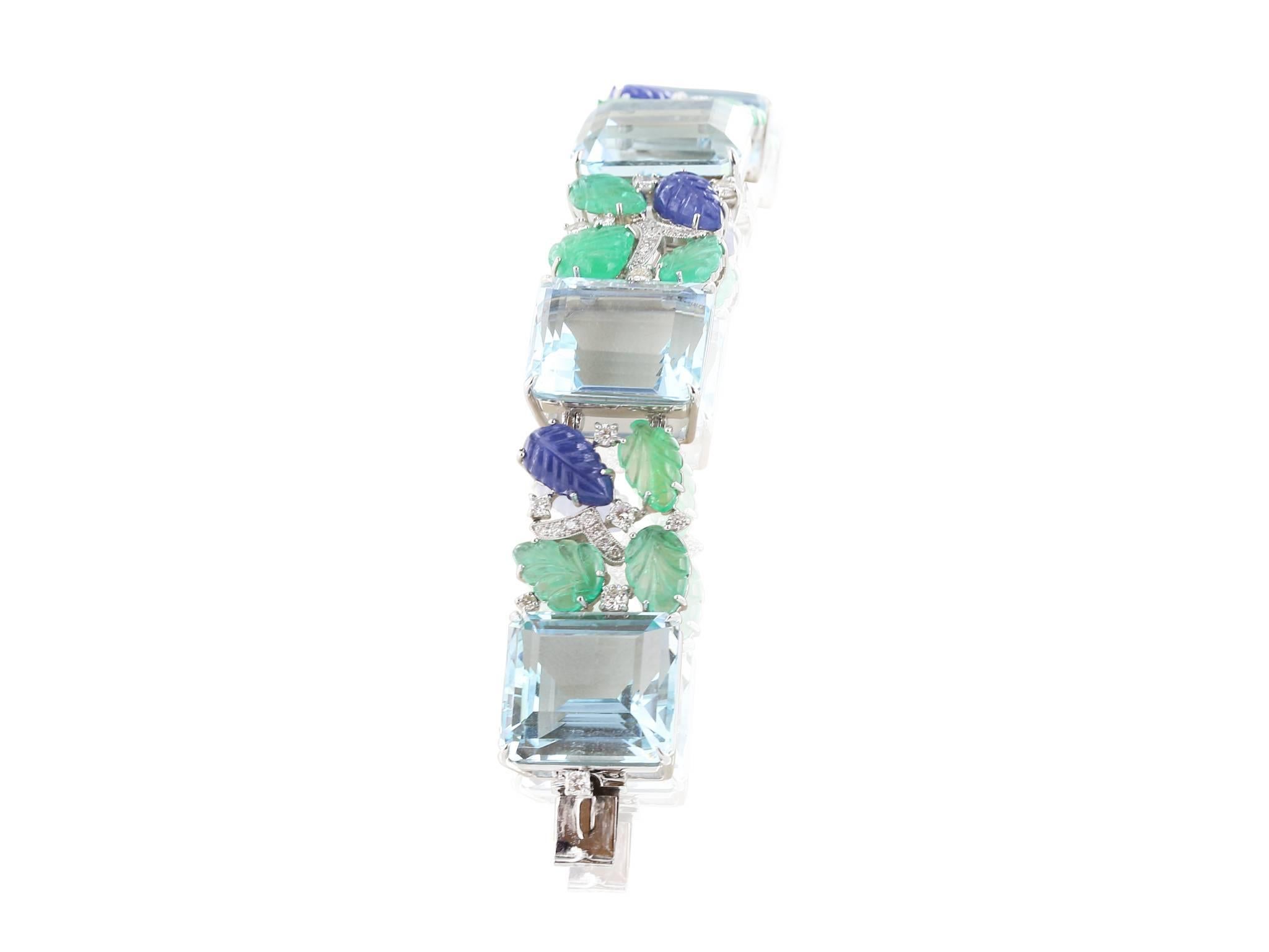 18 karat white gold Aquamarine, sapphire and emerald  vintage style bracelet, consisting of 6 emerald cut aquamarines, 122.15 carats, 18 carved leaves style emeralds, 19.48 carats, 6 carved leaves style blue sapphires, 11.21 carats and 1.91 carats