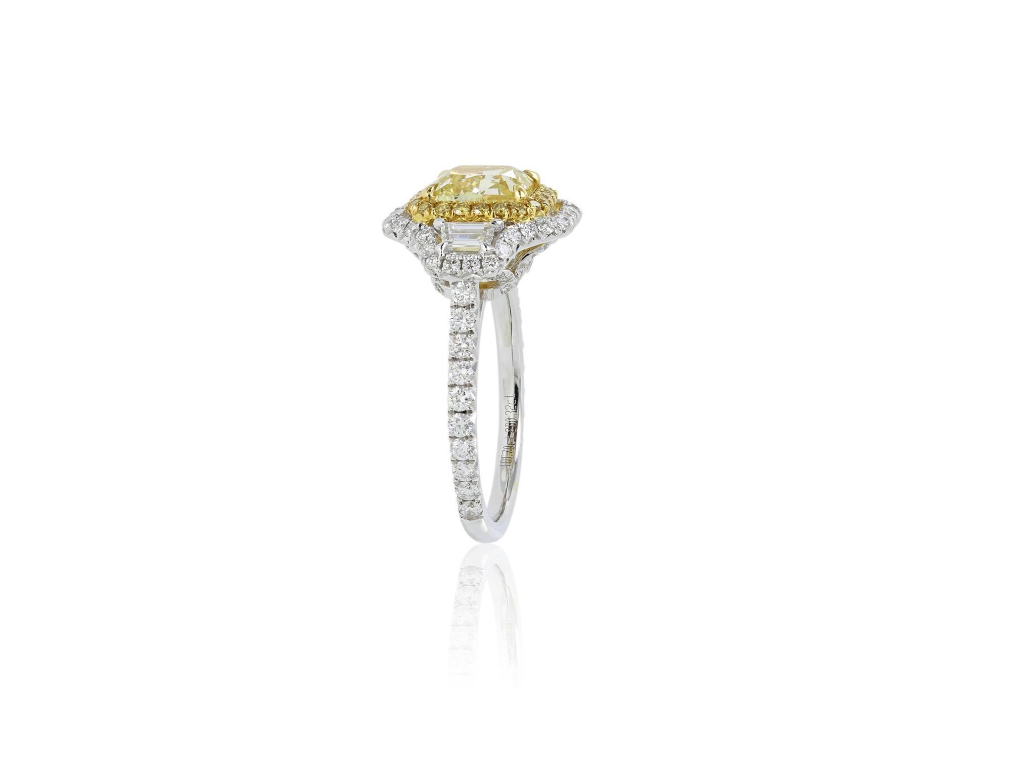 18 karat two tone ladies Canary Diamond ring featuring one rectangle radiant cut diamond weighing 1.70 carats with a GIA certificate Fancy yellow SI1, respectively flanked by 2 trapzoid diamonds, with a halo of diamonds and diamonds set on the shank