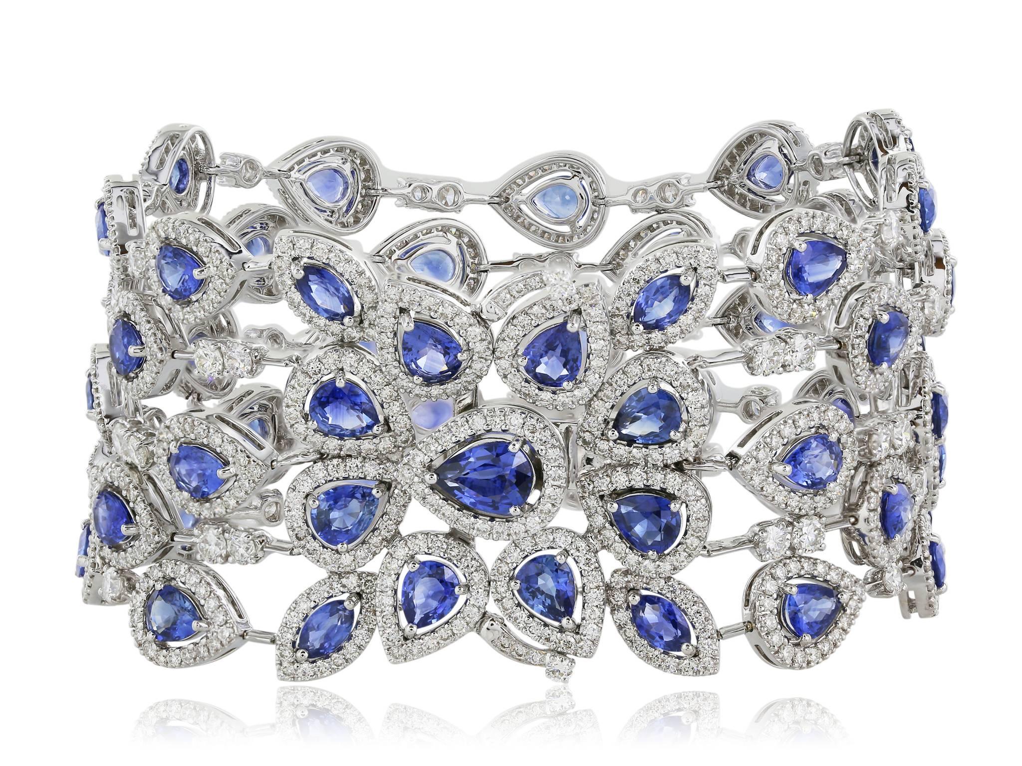 Flexible 18 karat white gold five strand bracelet featuring 19.48 carats of pear shaped sapphires. Each sapphire is surrounded by a halo of round brilliant cut white diamonds.  Interspersed amongst the sapphires are .10 carat round brilliant cut