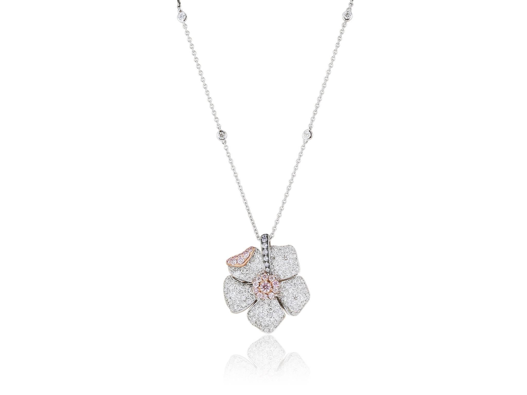 18 karat white gold flower pendant consisting of round Fancy Purplish Pink/Fancy Pink/Fancy Pink diamonds having a total weight of .60 carats, with 7 round Argyle blue diamonds having a total weight of .11 carats and round white diamonds having a