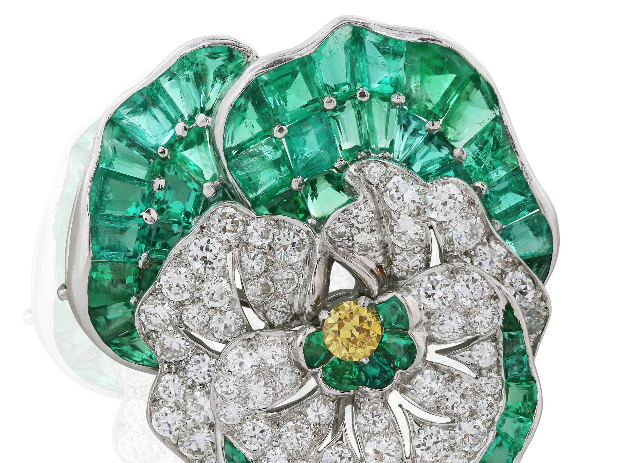 Platinum Pansy Brooch centering one old European-cut fancy colored yellow diamond approximately .20 carat and emeralds approximately 9.00 cts the emerald pansy signed Udall & Ballou.