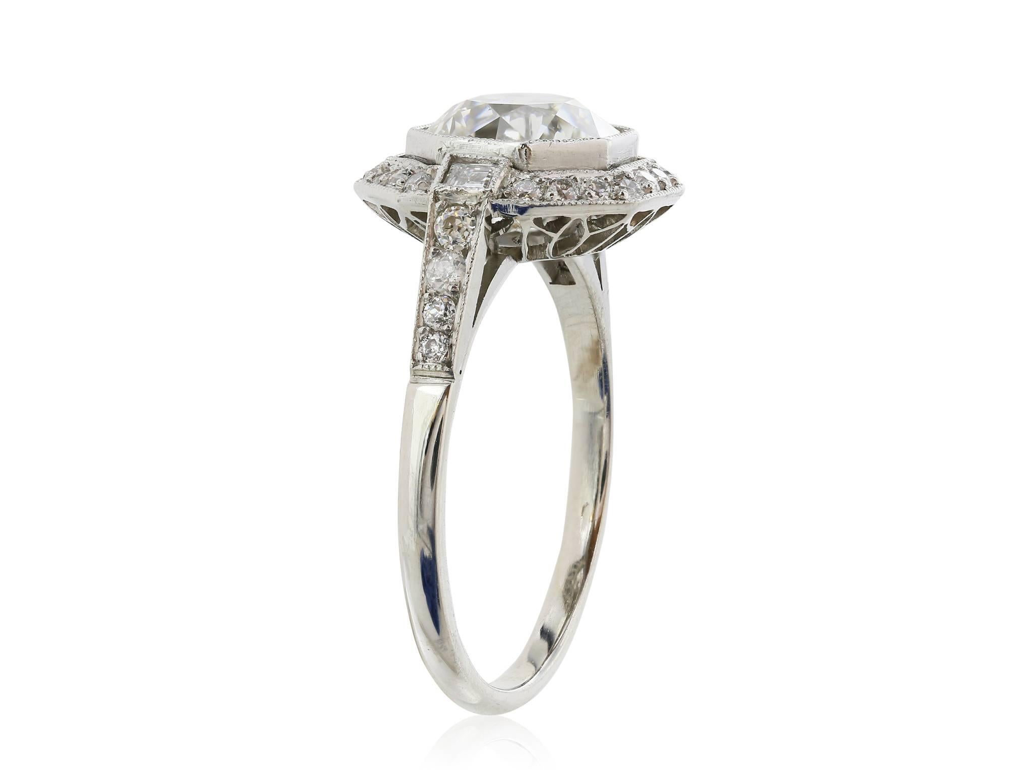 18 Karat white gold antique inspired diamond ring with one 2.18 carat Old European cut diamond with a color of J and a clarity of VS2.  The diamond is surrounded by a row of round brilliant cut white diamonds weighing approximately .50 carats set in