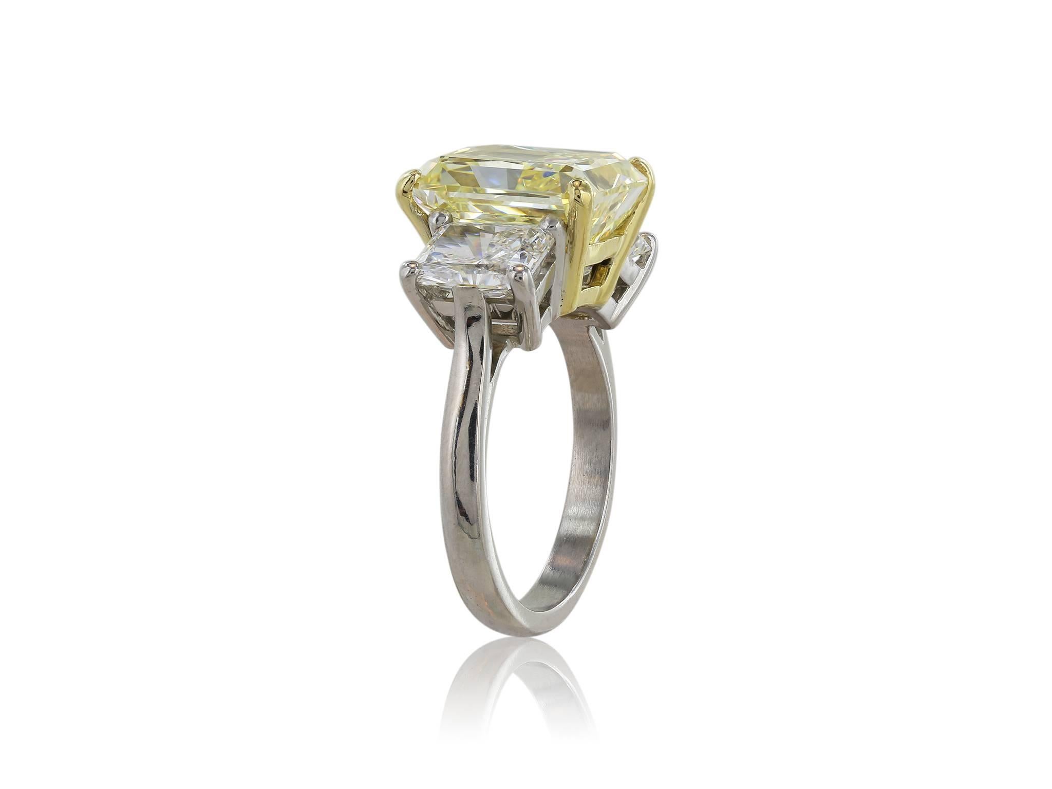 Platinum 3 stone natural canary ring consisting of 1 fancy yellow radiant cut diamond weighing 5.87 carats measuring 10.58 x 9.58 x 6.25 mm, color and clarity of FY/VS2 with GIA Report 12239258,flanked by 2 radiant cut white diamonds with a total