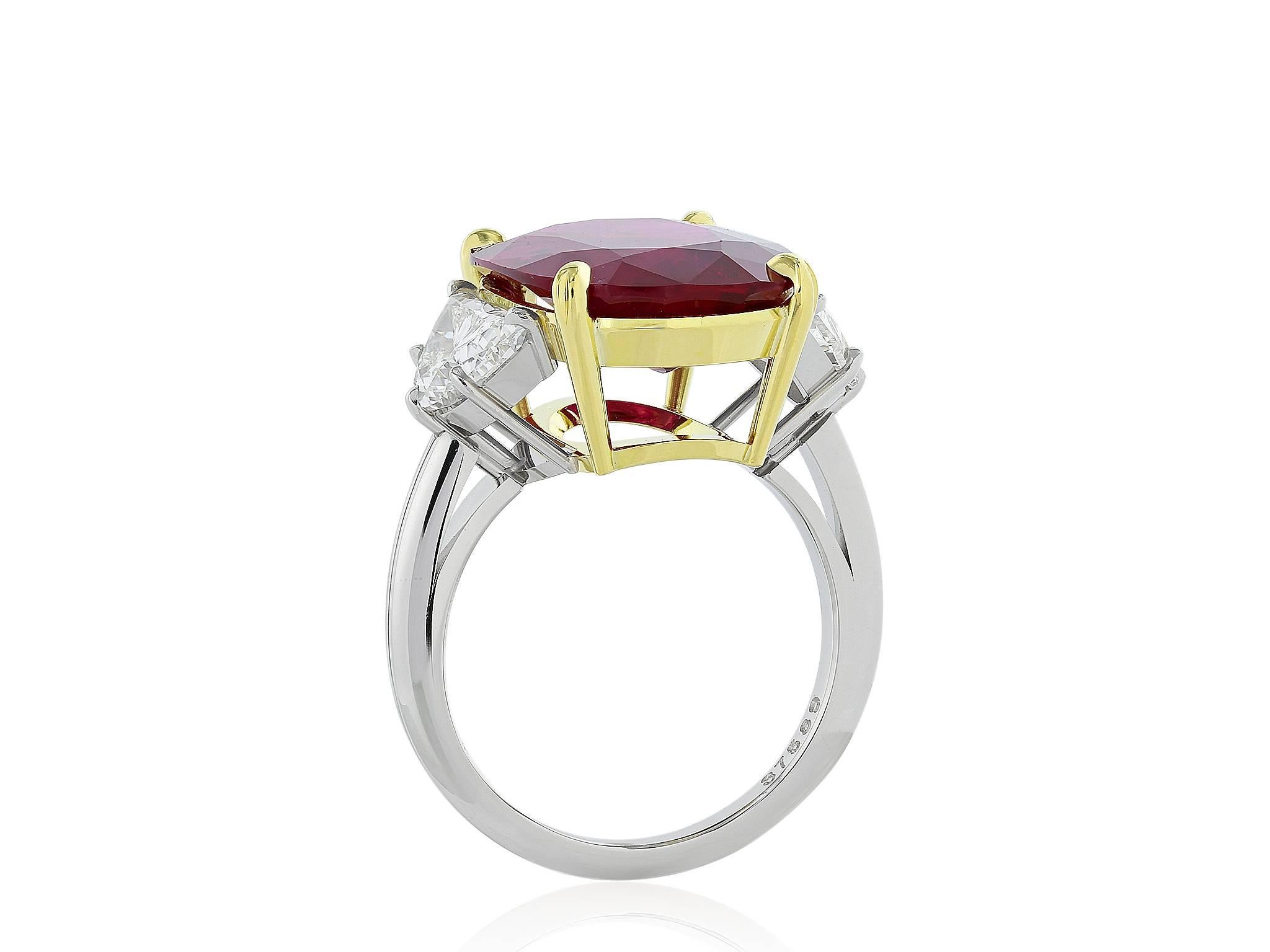 Platinum set three stone ring consisting of one AGL certified (AGL cert #CS 67238) cushion cut ruby weighing 10.24 carats of Thai origin.  The Ruby is flanked by 2 half moon shaped diamonds a combined carat weight of 1.75 carats, a color of F and a