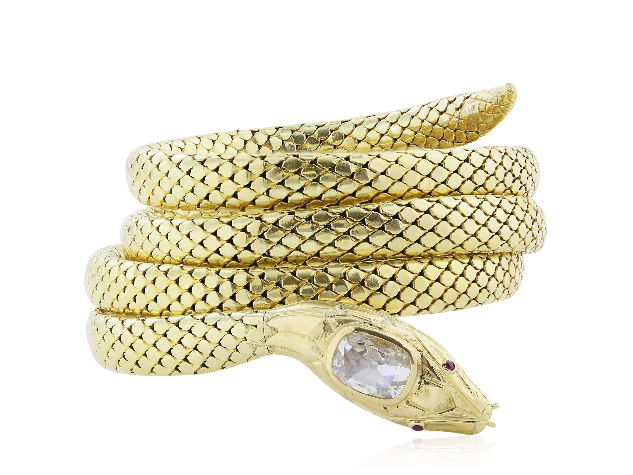 18 Karat yellow & white snake bracelet made out of four coils of hand made woven mesh. The bracelet is finished with an intricate snake head set with an approximately 2 carat cushion cut diamond and with ruby eyes.