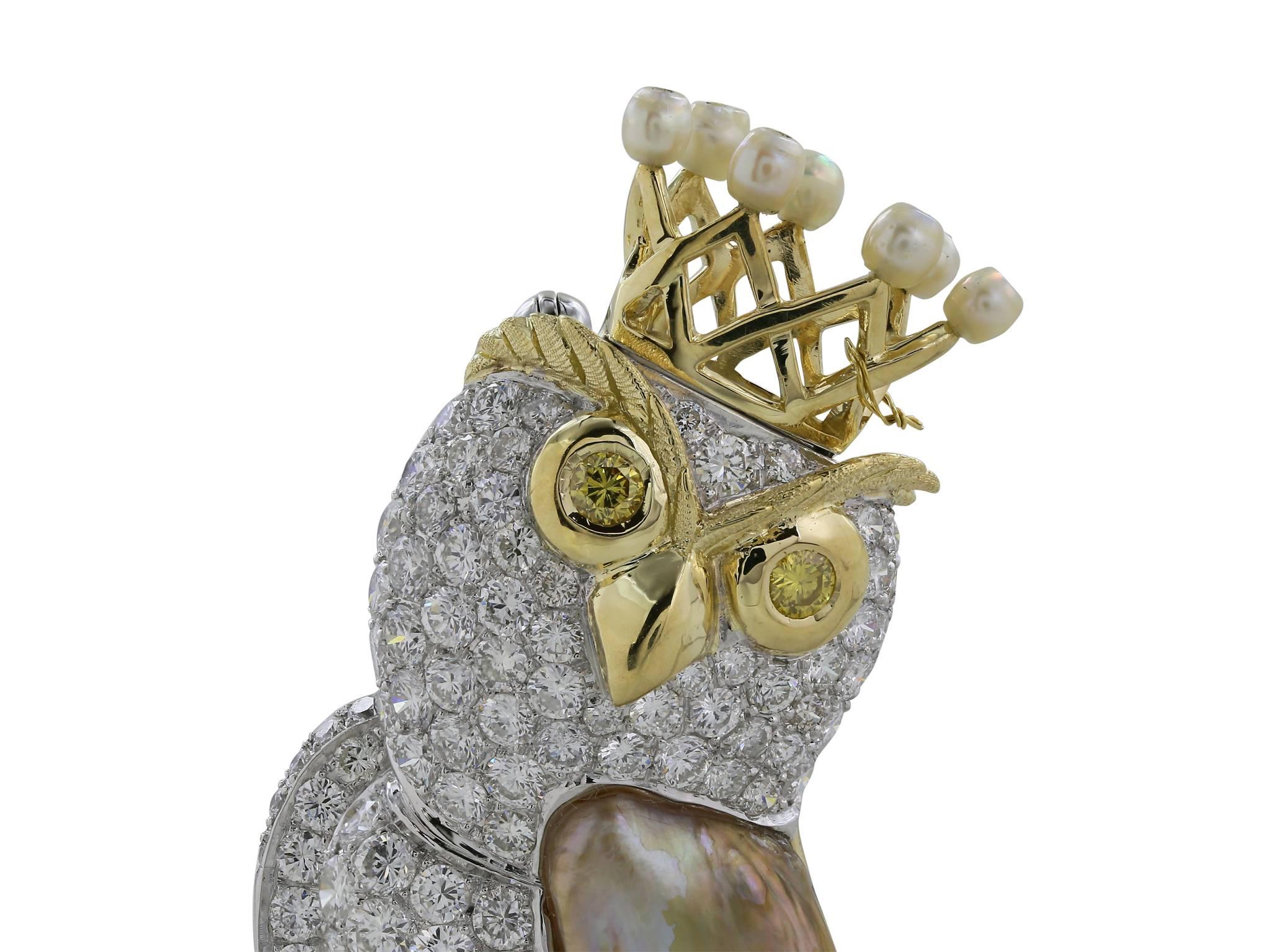 Vintage owl pin with approximately 1.50 carats of round brilliant diamonds, with 7 pearls gracing the crown, a hand carved mother of pearl wing, and two round yellow diamonds for the eyes, set in 18 karat white and yellow gold.