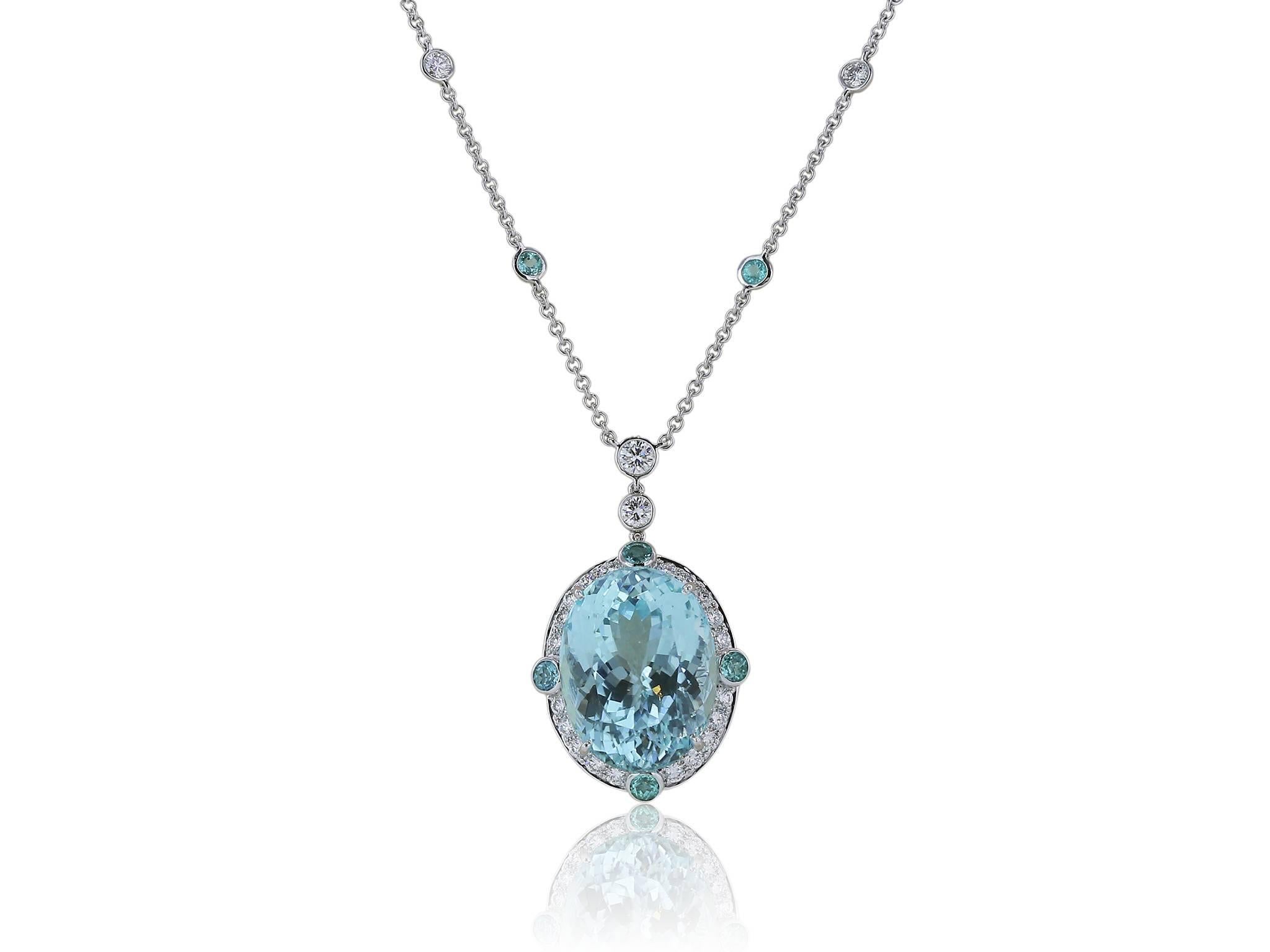 18 karat white gold custom made Paraiba Tourmaline and diamond pendant with chain consisting of one  22.60 cts. oval GIA #2185506310 19.90 x 15.14 x 11.66 mm surrounded by 26 full cut diamonds weighing and 8 round Paraiba Tourmaline having a total