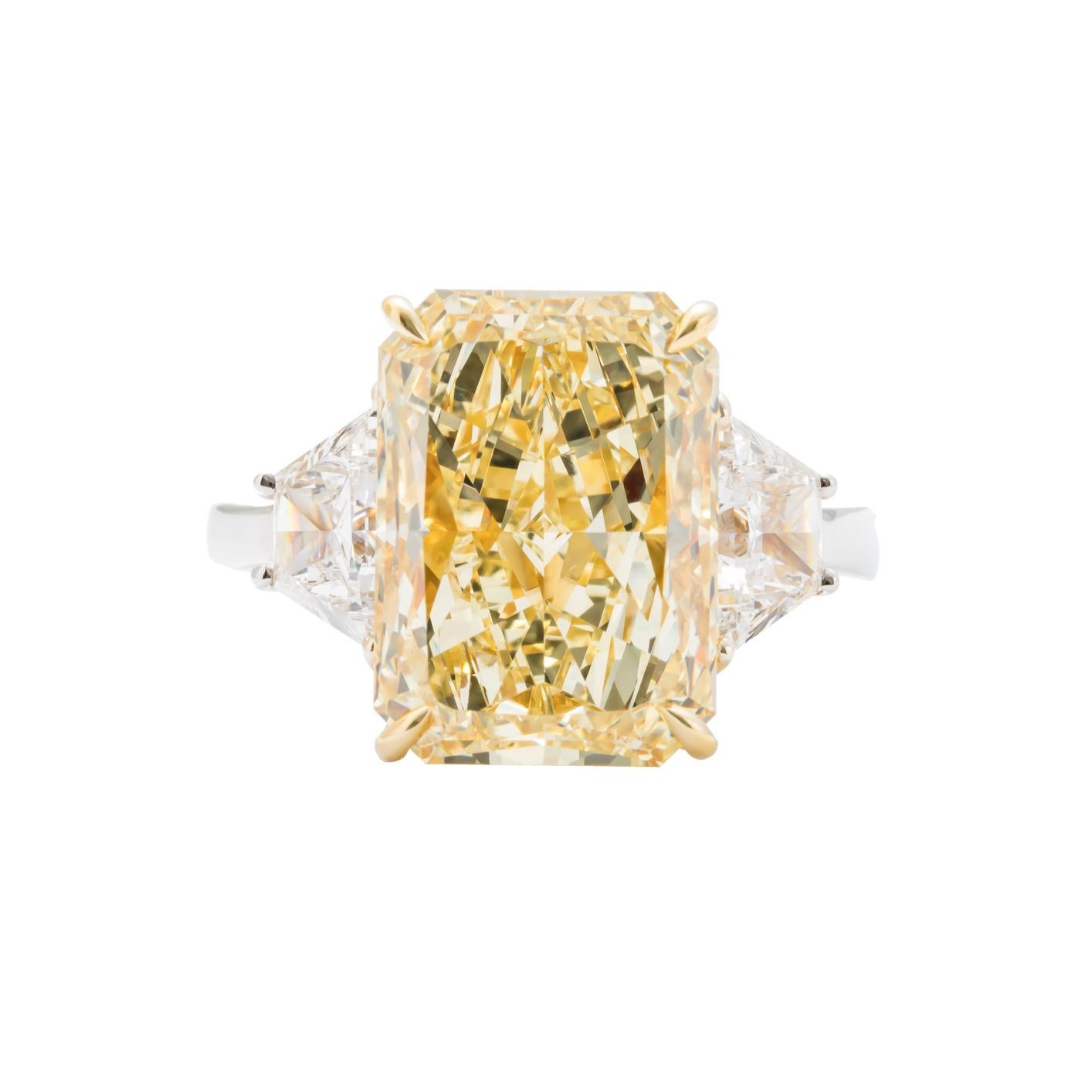 Platinum & 18 karat yellow gold 3 stone ring consisting of one radiant cut yellow diamond weighing 7.95 carats with color and clarity of FY/VS2 GIA # 1186712477 flanked by 2 trapezoid diamonds weighing a total of 1.28 carats. Size 6.5