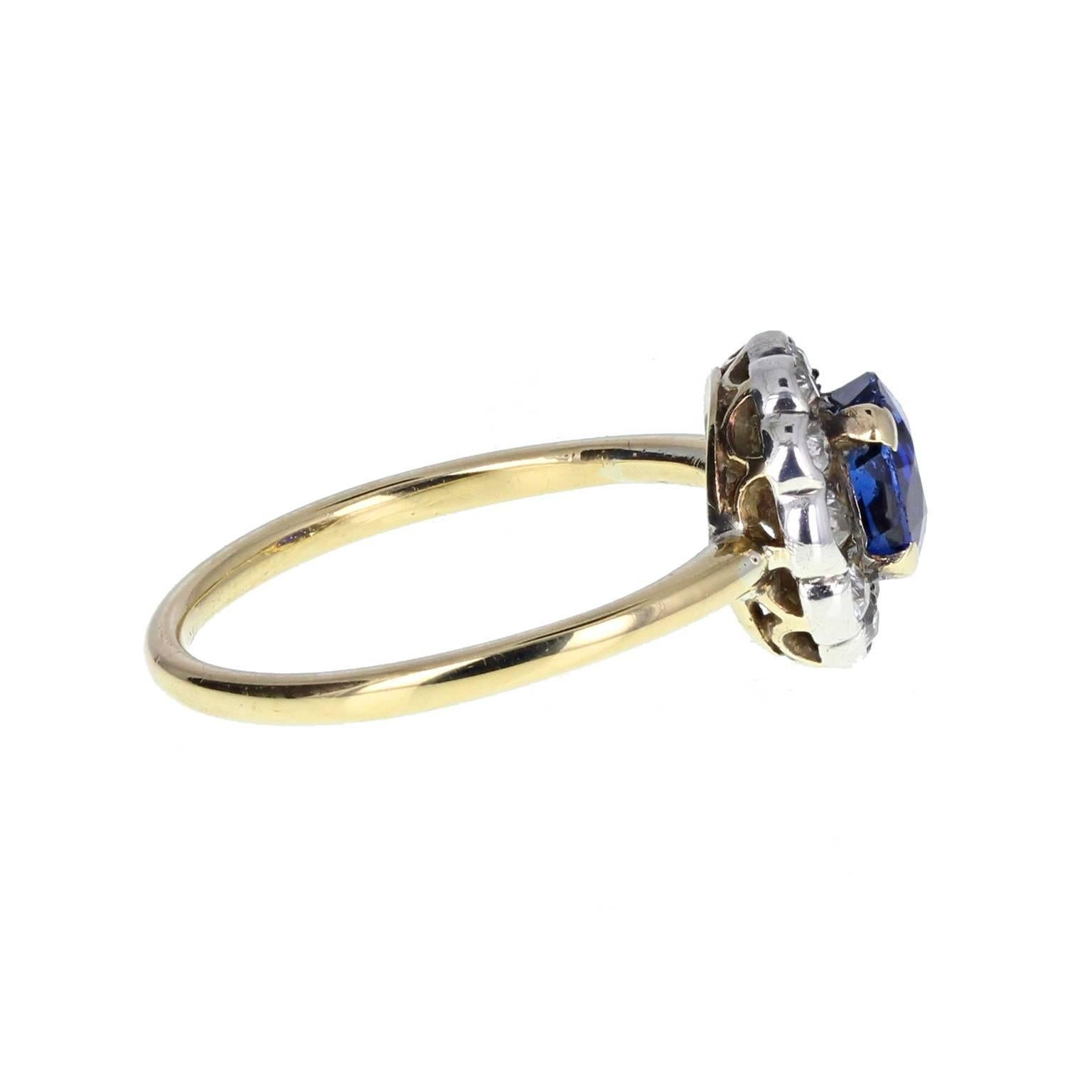 This sweet period ring features a central round-cut sapphire of exceptionally pleasing velvety blue, mounted in four claws and surrounded by single-cut diamonds to form a round cluster of approximately 10mm in diameter.
 
Shank and Setting
Tests