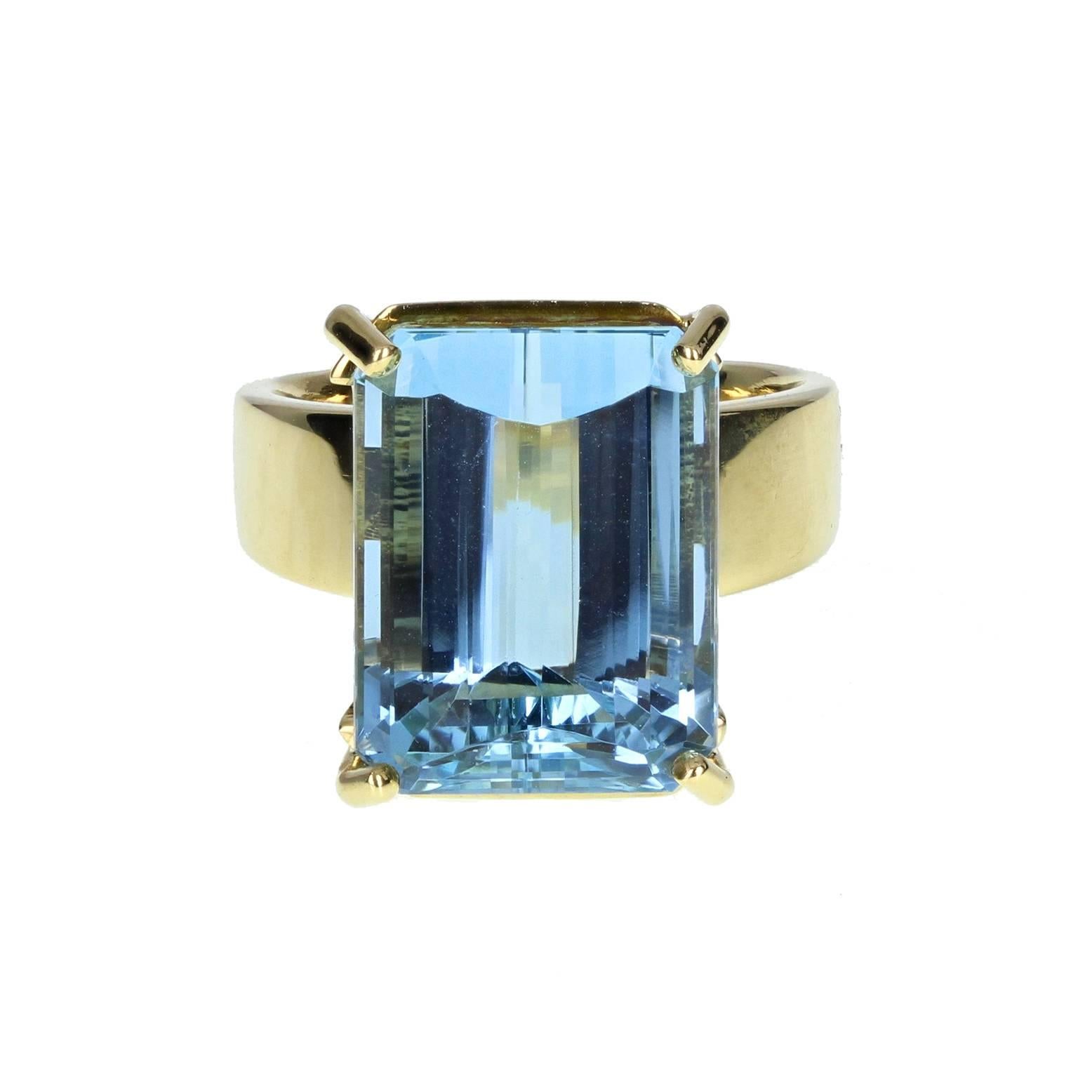 An exceptional cocktail ring fashioned from 18 carat gold. Simple, modern four-claw setting mounted with a single modified emerald-cut aquamarine of very fine quality. Wide shank tapers and terminates with a moulded lions/panthers head. Stamped