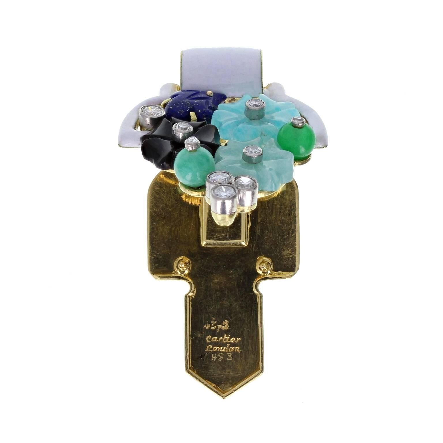A fine example of the famed Cartier Tutti Frutti jewellery. In excellent condition, this clip is adorned with carved jade, emerald, lapis lazuli, black onyx and enamel in a floral pattern, accented with round cut diamonds. Signed 'Cartier London'.