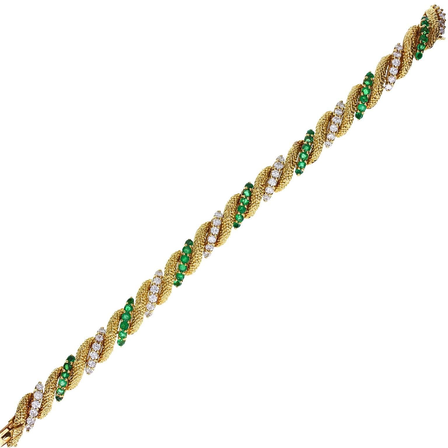 A fine quality bracelet by Van Cleef & Arpels. Circa 1960s. Comprising gold links with applied textured effect, alternating with links claw-set with brilliant-cut diamonds or emeralds. Gemstones all beautifully matched. Tongue type fastening with