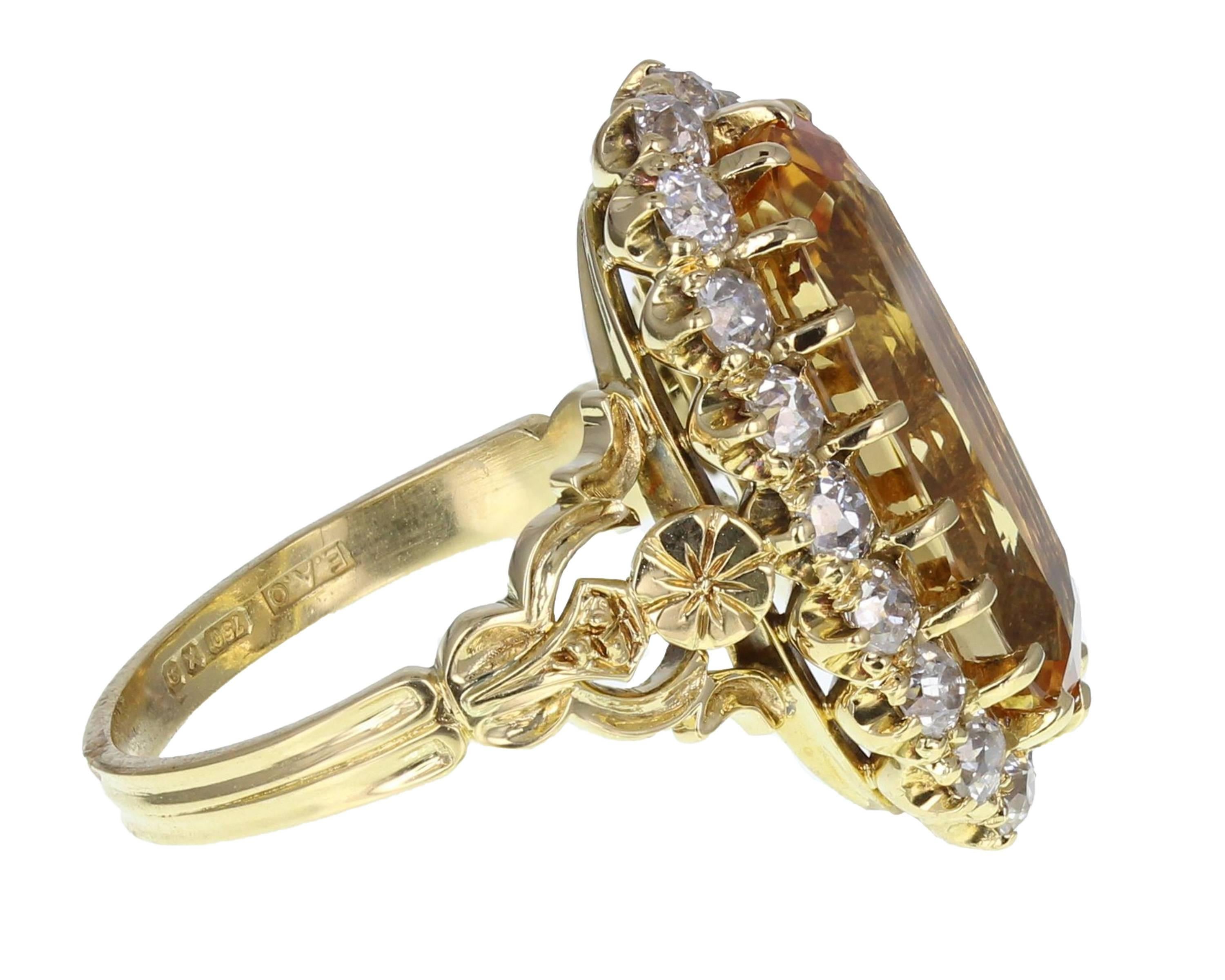 This beautiful, lozenge shaped cluster ring in 18-carat yellow gold is a fine example of early 1900's style. The long, oval brilliant-cut yellow Topaz has beautiful honey tones that are perfectly complimented by the fancy 18-carat yellow shoulders.