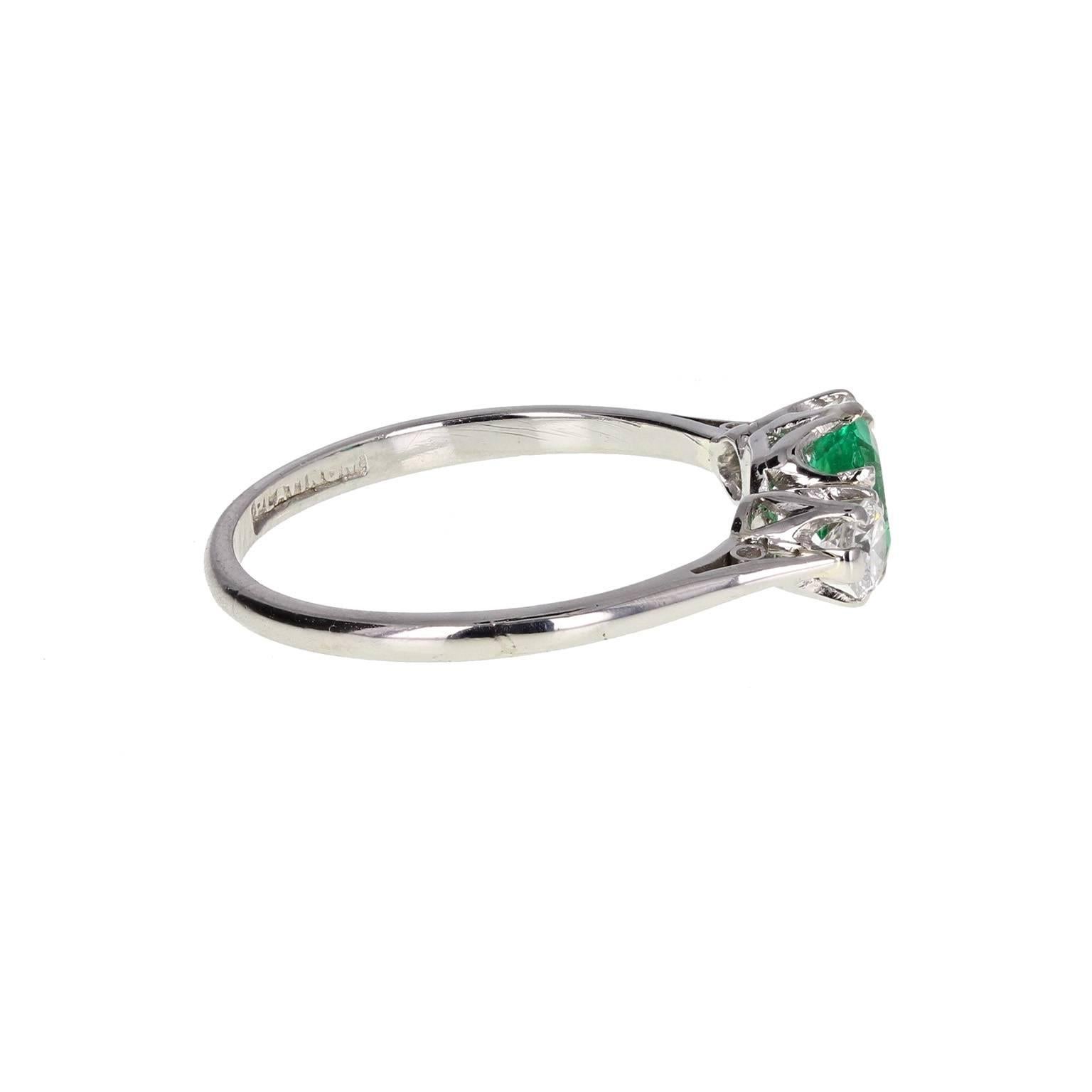 A petite and elegant three stone ring in platinum. The central, quality emerald, flanked by two round, brilliant-cut diamonds, mounted in claws.
 
Shank and Setting
Tests as platinum
 
Emerald
Weight: 0.50 of a carat
 
Diamond
Weight: 0.30 of a