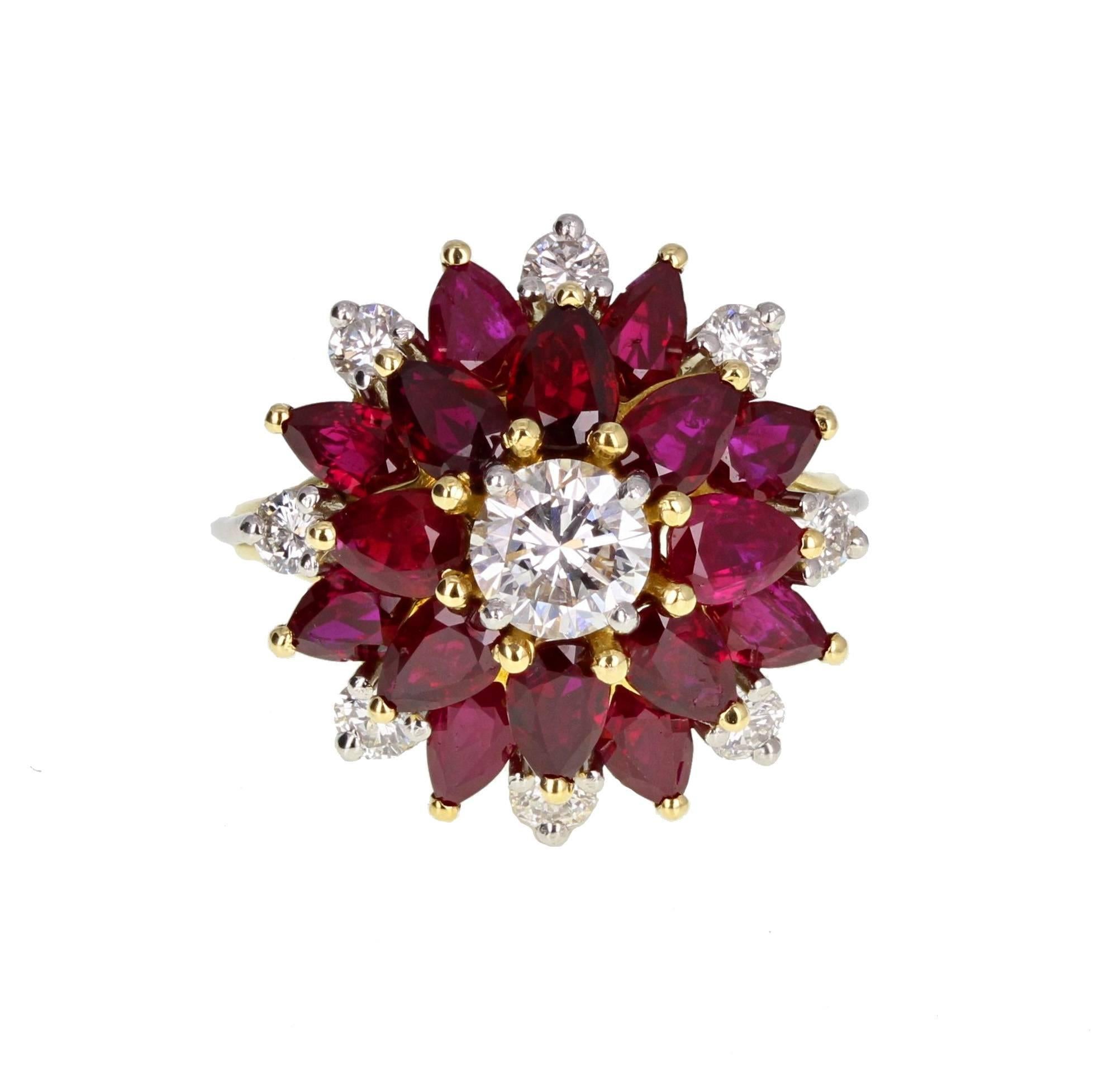 A fine and impressive cluster ring featuring high quality gemstones. Comprising a central half-carat brilliant cut diamond, mounted in claws, surrounded by pear-shaped rubies to form a flower shaped cluster. Accented with smaller diamonds. White and
