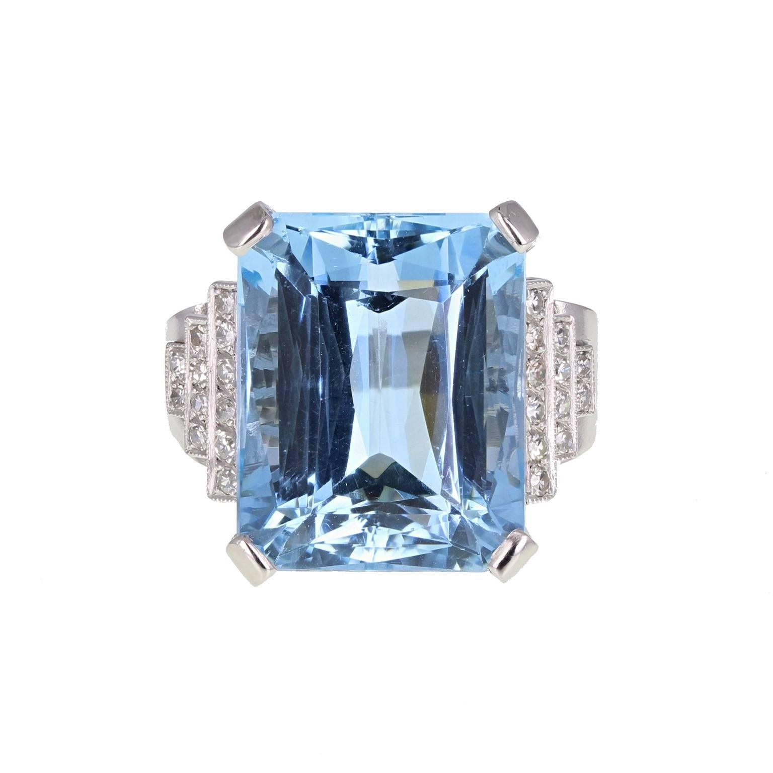 A very fine quality Art Deco ring featuring a central 28 carat radiant-cut aquamarine of exceptional colour, mounted in four claws. Triple stepped shoulders, pavé-set with single-cut diamonds. Pierced scroll work to the underside of the setting. An