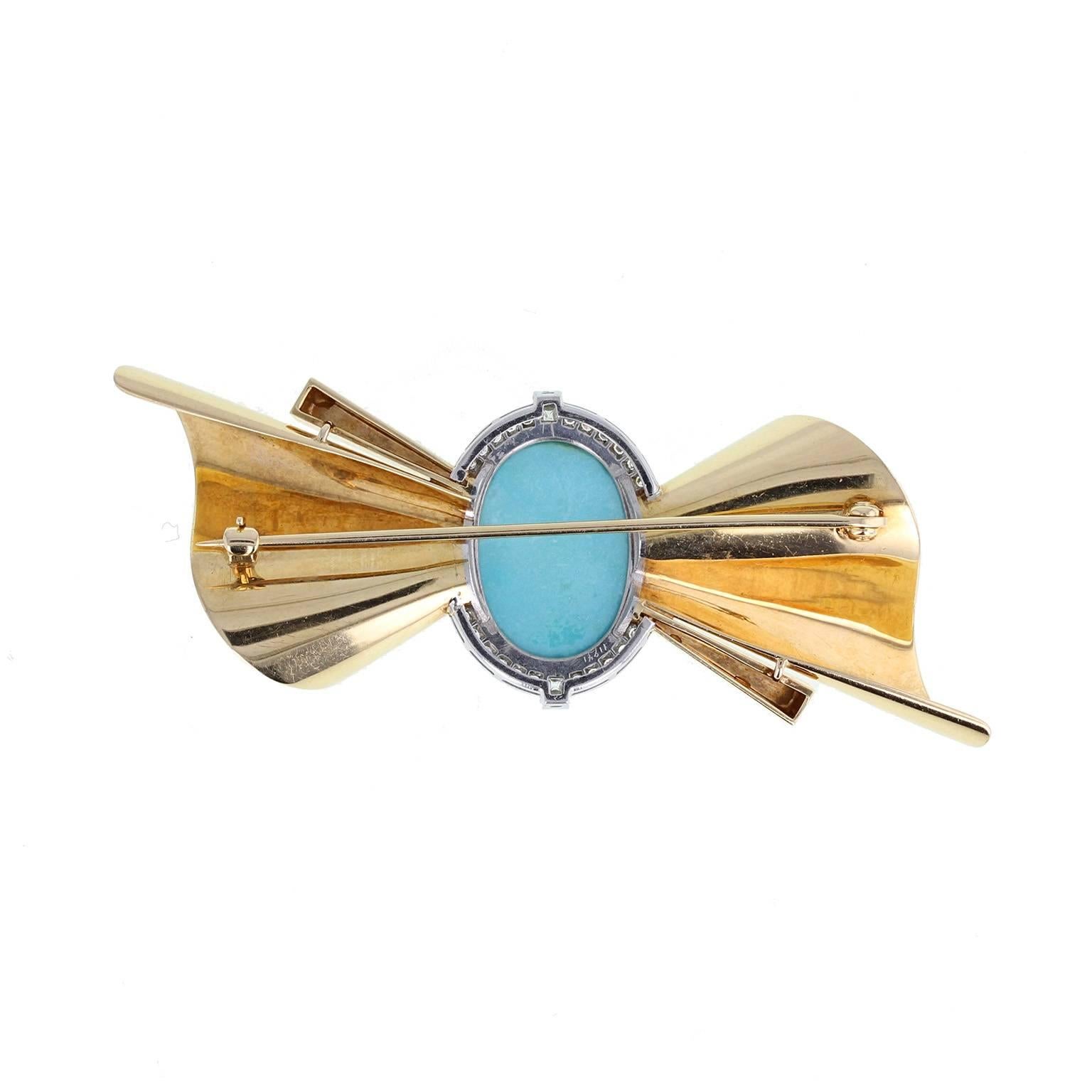 A fine and impressive retro brooch featuring a central oval turquoise cabochon, bordered with brilliant-cut diamonds, enveloped in scrolls of gleaming gold to form a bow-type shape.
 
Setting
Tests as 18 carat gold
 
Diamond
Weight: 0.30 of a carat