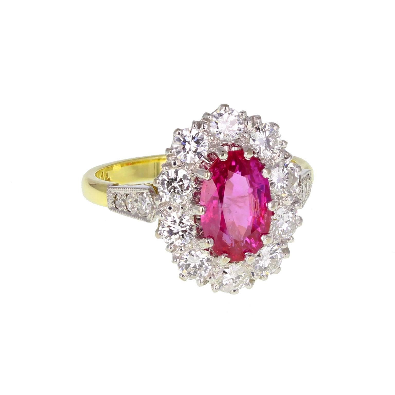 A fine, bright and impressive ruby and diamond oval cluster ring. The central Burma ruby mounted in claws, surrounded by 10 brilliant-cut diamonds of approximately 0.15 of a carat each, also in claws, to form the oval cluster. Three brilliant-cut