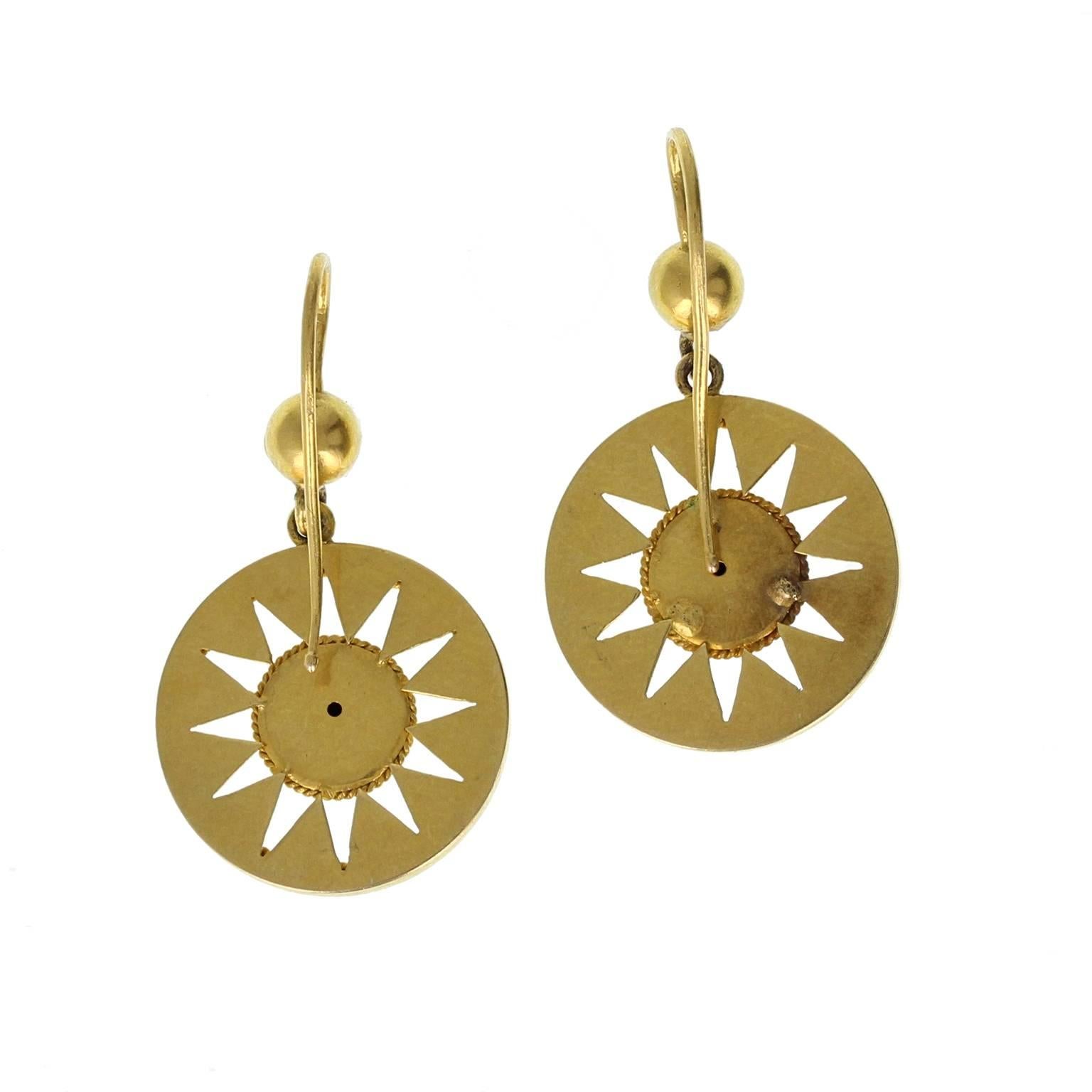 An exquisite pair of Etruscan style drop earrings in 15ct gold. The pierced starburst effect disks, decorated with rope-effect detailing hang from a gold bead, with shepherds hook style fixing for pierced ears.
 
Setting
Tests as 15ct gold
