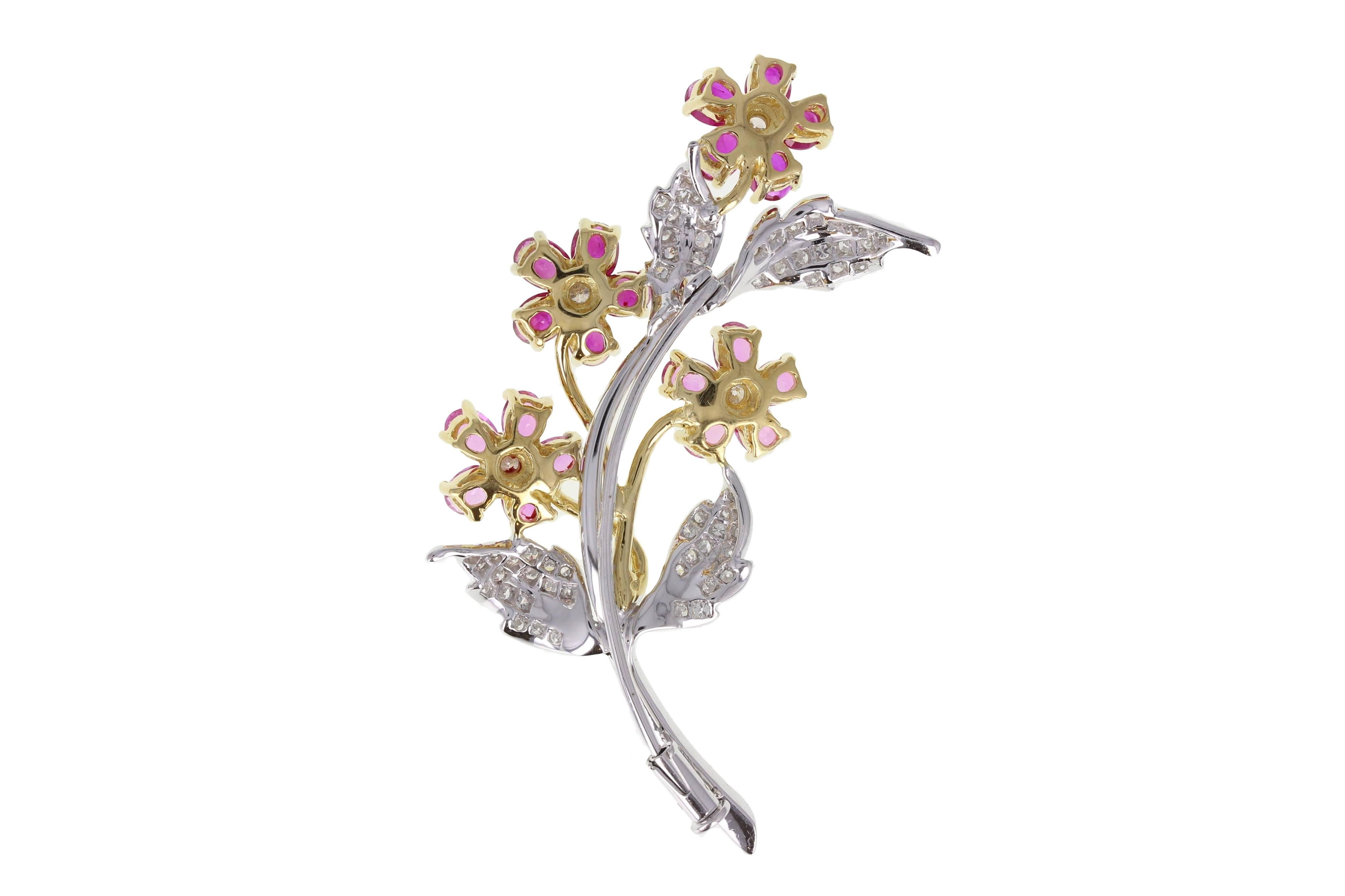 A pretty floral brooch comprising of four 18-carat yellow gold flowers made up of five oval shaped pink sapphires with a diamond centre, interspersed with four 18-carat white gold leaves, pavé set with round brilliant-cut diamonds. 
Setting
Tests as
