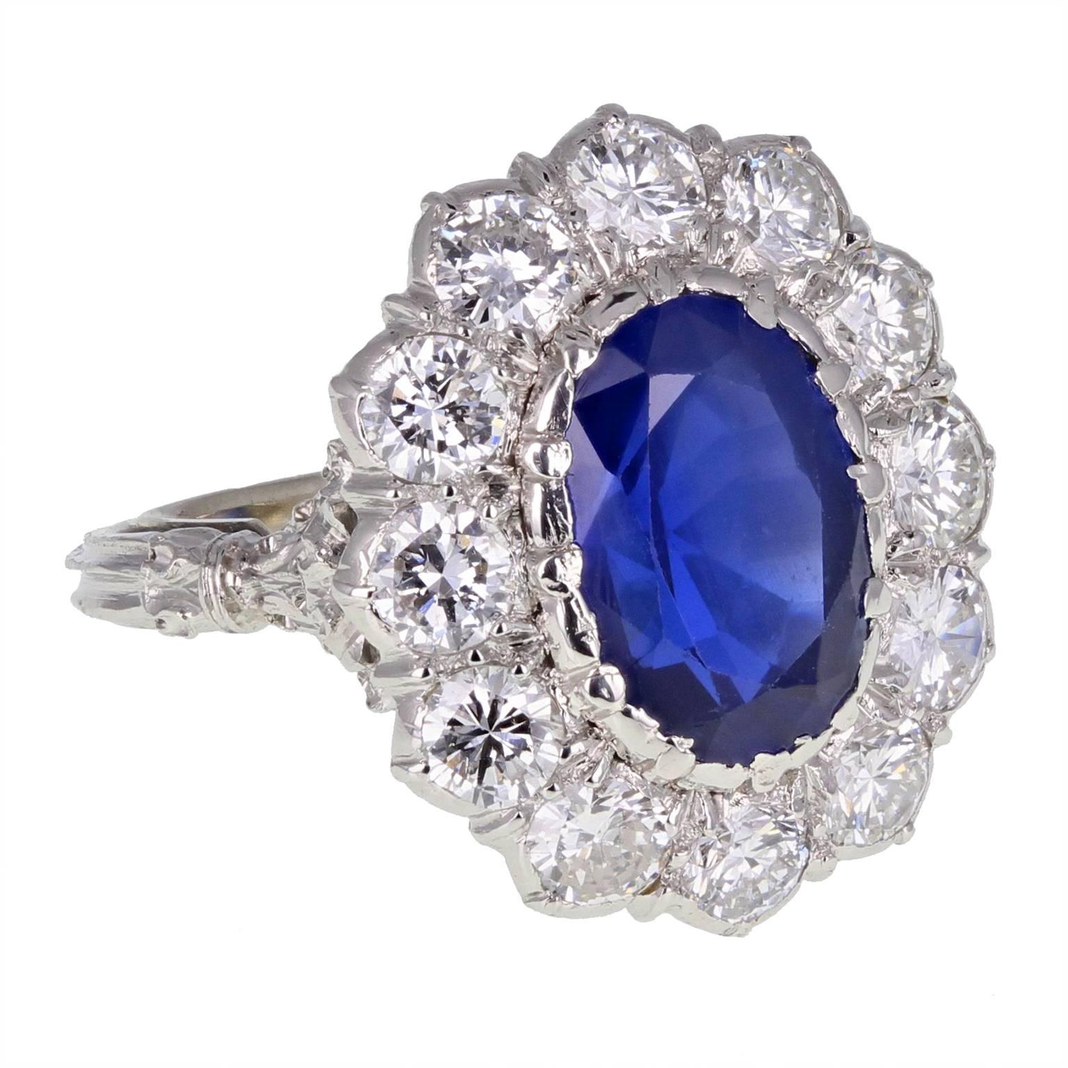 An exquisite Burma sapphire and diamond cluster ring by Buccellati. The oval, unheated sapphire surrounded by bright and lively brilliant-cut diamonds. Highly decorated shoulders and reeded shank. Signed Buccellati.
Specifications:
 
Shank and