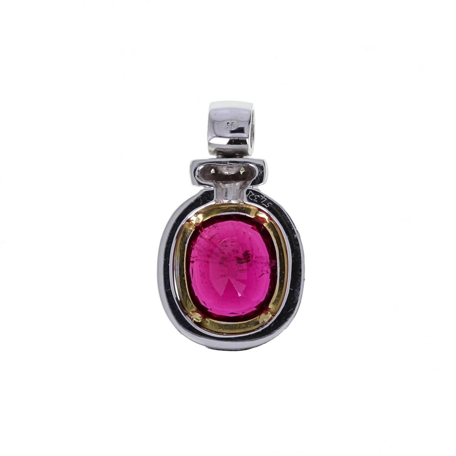 A fine quality modern pendant. Single large cushion-cut tourmaline of deep pink, set in a double collar of yellow and white gold, suspended from a diamond set bale. The excellent colour of this tourmaline mimics the colour of the finest Burma