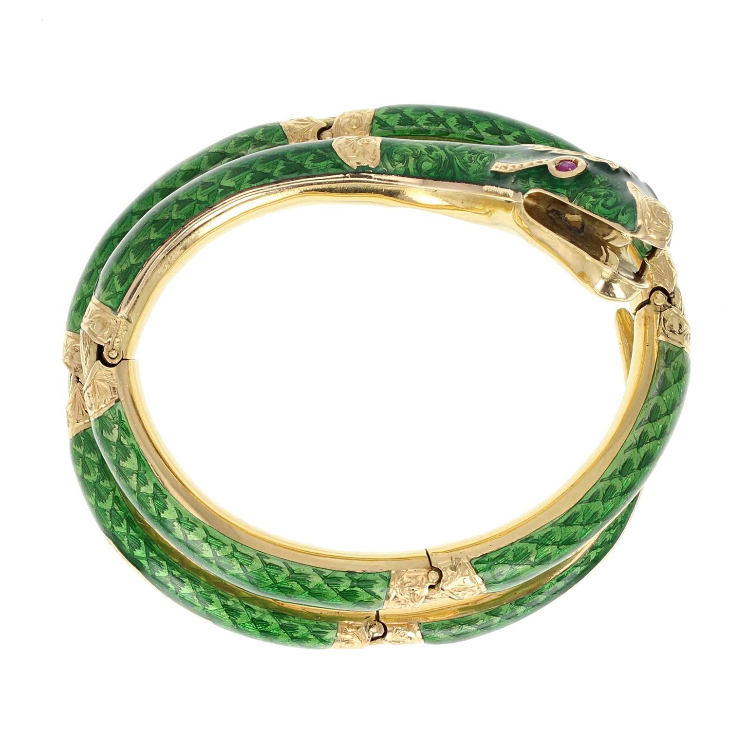 A fine and impressive serpent / snake bangle from c1950. The hinged, articulated bangle modelled as a coiled, hissing snake, it's body a bright and vibrant green guilloché enamel. The head adorned with a single marquise-cut diamond and two Burma