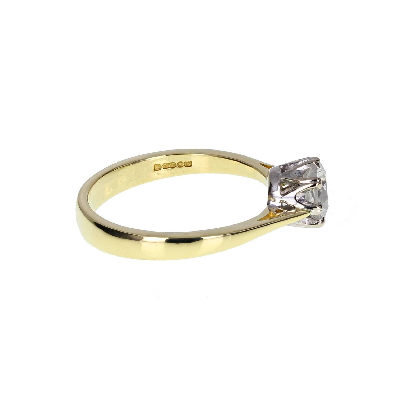 A fine quality diamond solitaire engagement ring in classic style. A one carat brilliant-cut diamond mounted in an 18 carat white gold 8-claw basket setting on a squared 18 carat yellow gold shank with knife-edge shoulders. London Hallmark 1994.