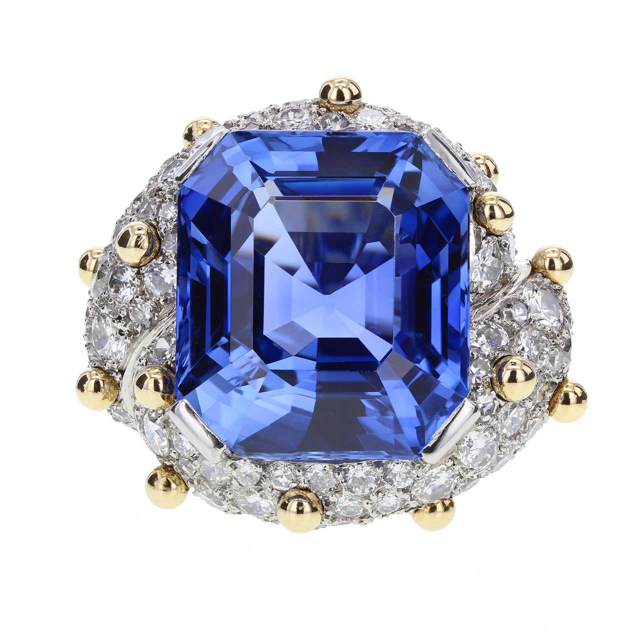 Central cut cornered step-cut gem quality sapphire weighing 30 carats, claw set within a pave set brilliant-cut diamond mount with beaded accents, above pave set brilliant-cut diamond shoulders, approximately 5 carats in total. Signed Schlumberger