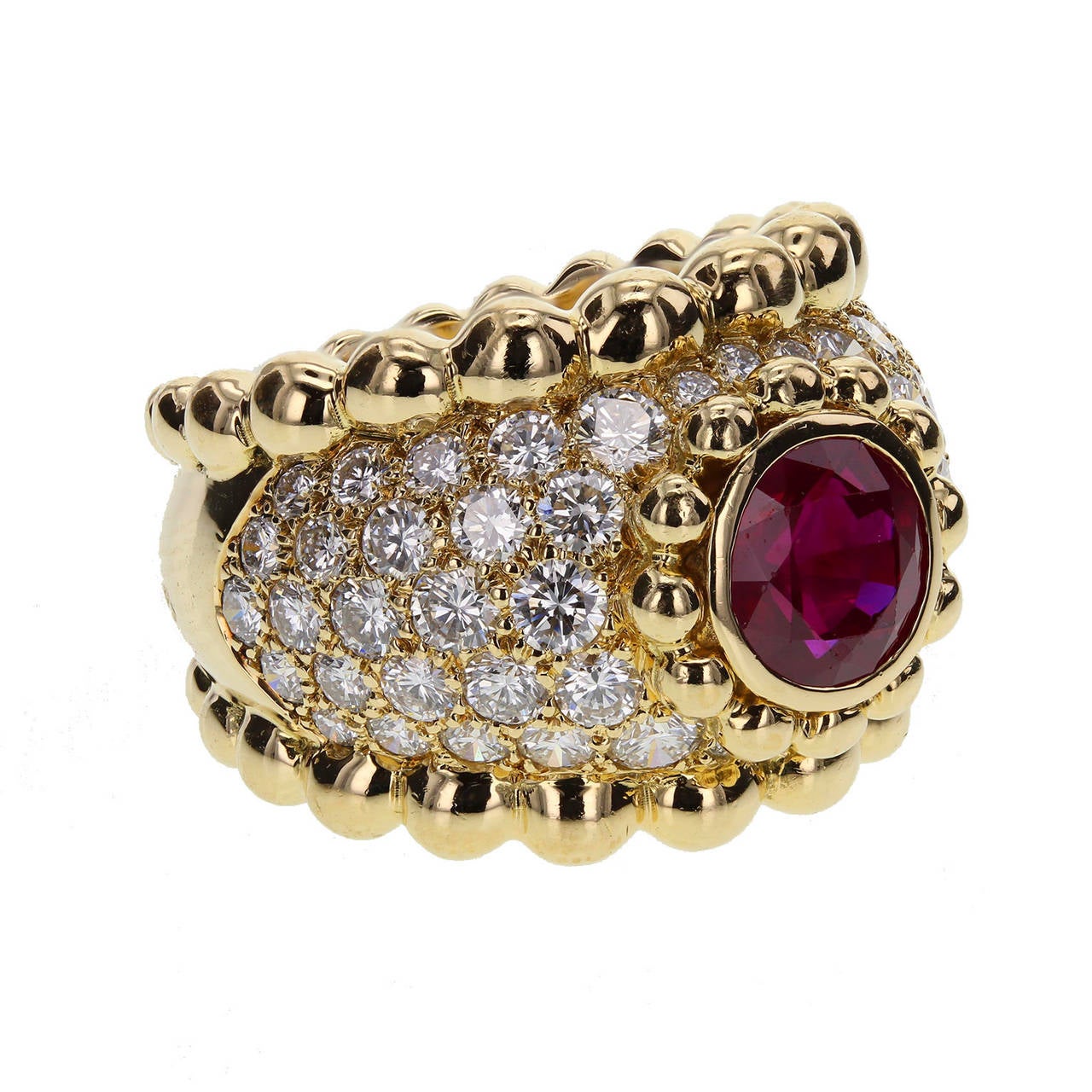From Chanel Paris, a central 1.40 carat brilliant cut ruby of exceptional blood-red colour, rubover set and decorated with gold bead surround, on a pave diamond band with gold bead edges. French marks.
Size J (leading edge)
