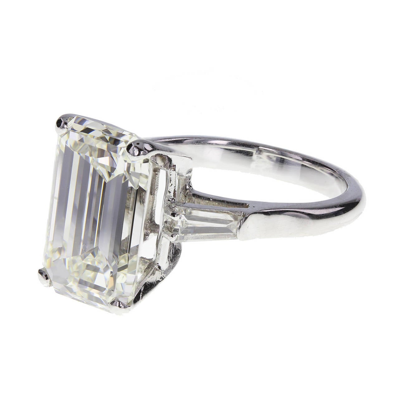 A large and impressive 6.07 carat emerald-cut diamond mounted in four claws. Flanked on each shoulder by a single tapered baguette-cut diamond. Uniform rounded shank. Accompanied by an HRD certifcate stating that the diamond is I colour and VVS2