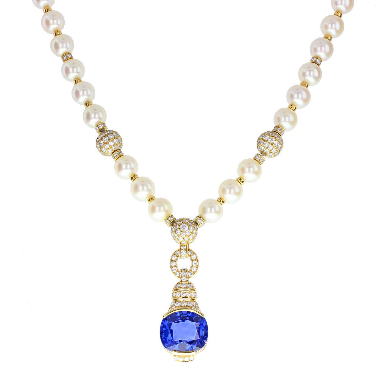 46 uniform cultured pearls of approximately 8.5mm strung to form a single row, terminating with a pave diamond gold bead from which a fancy diamond pave setting is suspended, mounted with a single 21 carat oval-cut blue sapphire.The front pearls are