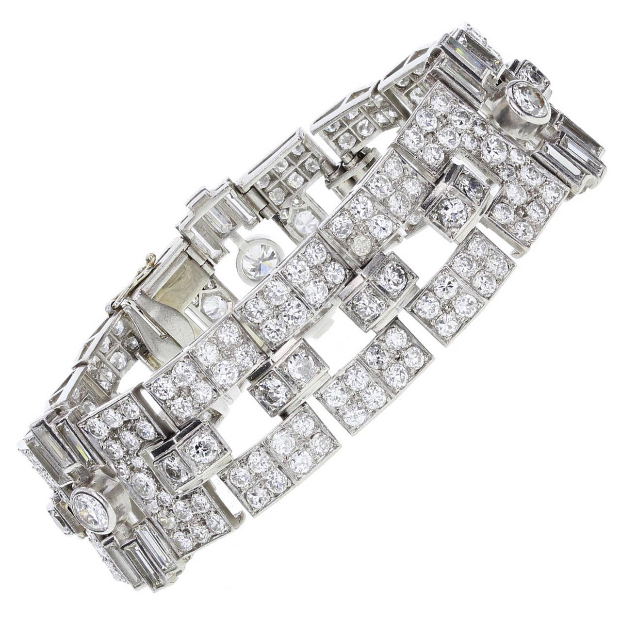 Single-cut and old European-cut diamonds pave set in platinum in this fantastic 1930s Art Deco bracelet. Three panels set with a single rubover set old-cut diamond to the centre, surrounded by baguette and single cuts. Each panel linked with three