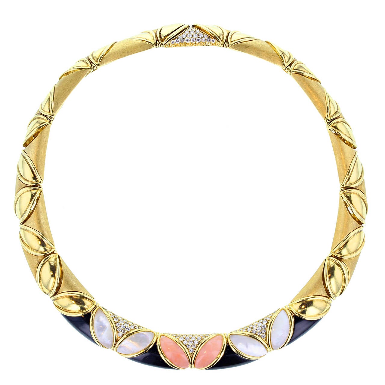The exceptional retro parure by Piaget is in fantastic condition. Comprising a collar, rigid bracelet and pair of earrings and formed with leaf-shaped/marquise-shaped motifs of gold, pink coral, white mother-of-pearl and accented with black onyx and