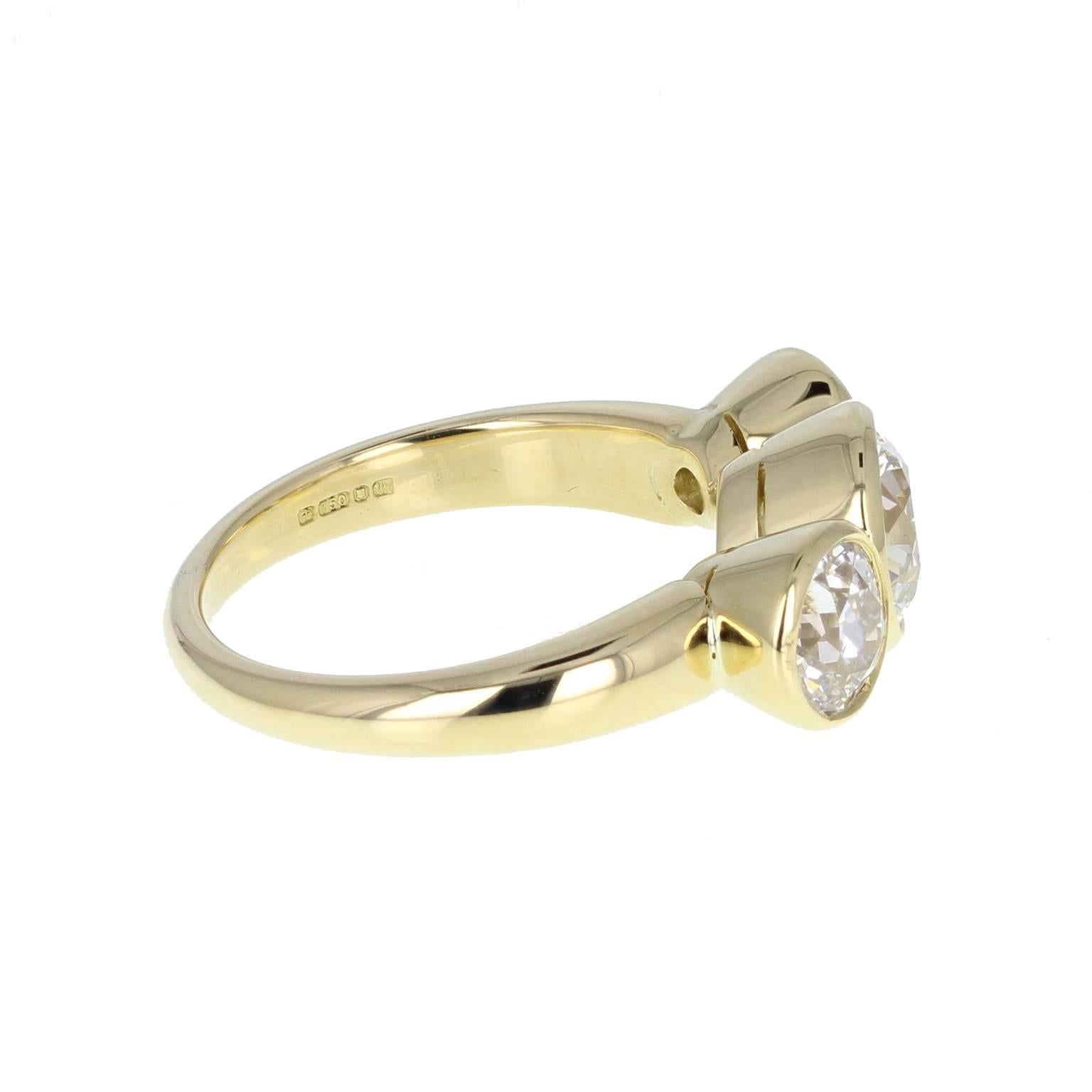 A modern ring, hallmarked London 1996 featuring three bright and lively brilliant-cut diamonds in a bezel/rubover setting. The centre diamond being slightly larger than the two flanking diamonds. Exceptional value. 

Shank and Setting
18 carat
