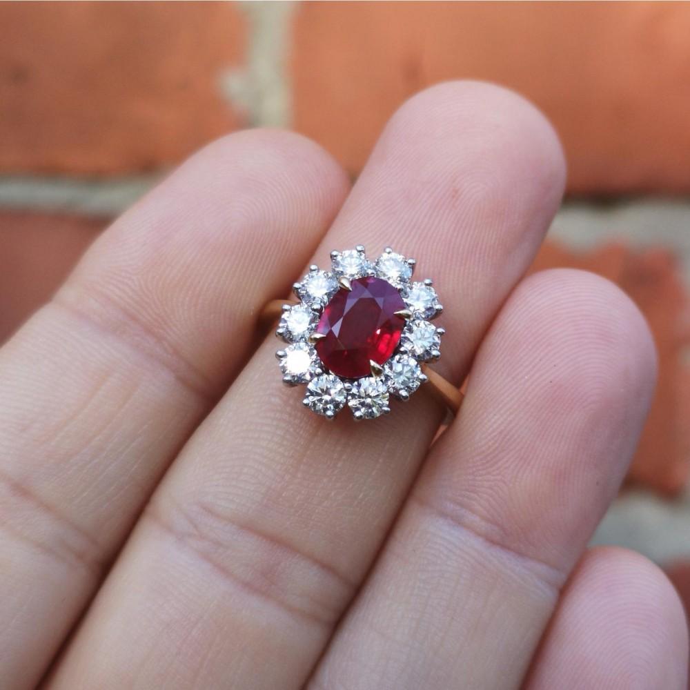 A very fine quality ruby and diamond cluster ring. The central, exceptional colour, blood red Burma ruby sits in four, beautifully pointed claws. Surrounded by 10 bright and lively brilliant-cut diamonds to form a cluster. A simple polished gold