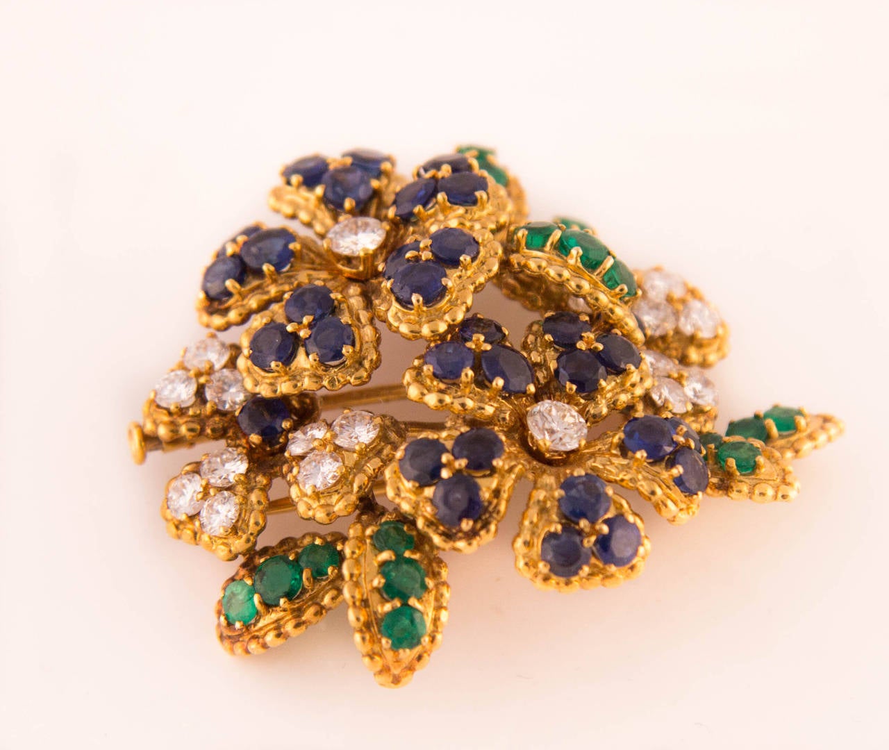 Mauboussin flower brooch beautifully set with brilliant cut diamonds, sapphires and emeralds