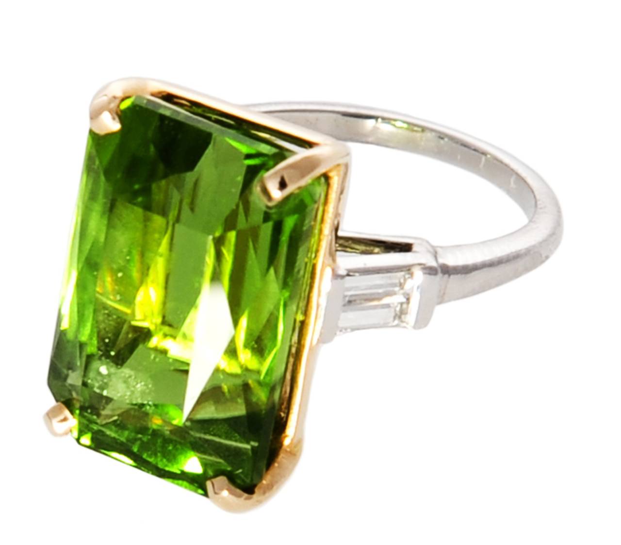 A beautiful lady's ring showing a clear Peridot approx. 19ct, 2 baguette cut diamonds VS2-SI1 total 0,35ct, size 6,25, resizeable