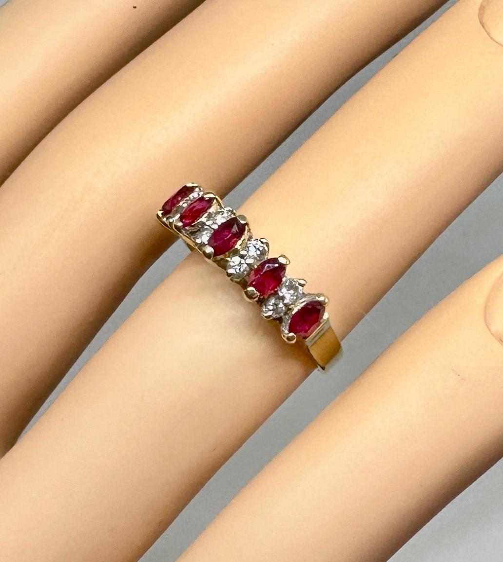 Laissez-vous séduire par une bague de fiançailles classique à rubis et diamants en forme de marquise.  Les cinq rubis rouge vif sont taillés en Marquise.  Les rubis alternent avec des paires de  Diamants ronds blancs étincelants.  Les cinq rubis et