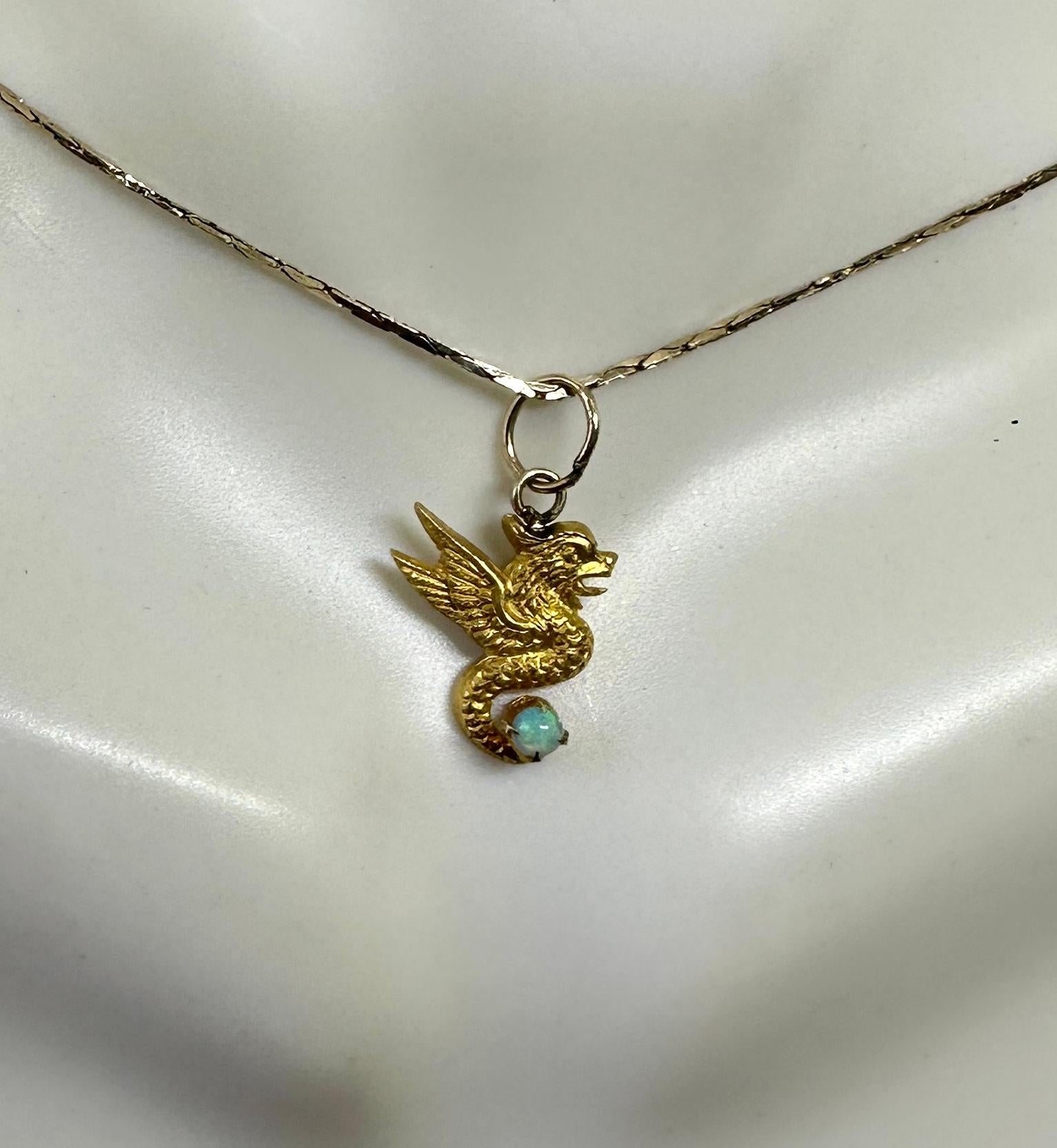 QUESTO È UNO SPLENDIDO CIONDOLO IN ORO DELLE BELLE ARTI BELLE EPOQUE RAFFIGURANTE UN GRIFONE O UN DRAGO ALATO CON UNA SPLENDIDA OPALE ANTICA ARRICCIATA SULLA CODA.
Si tratta di un bellissimo ciondolo Beaux Arts - Art Nouveau - Belle Epoque e risale